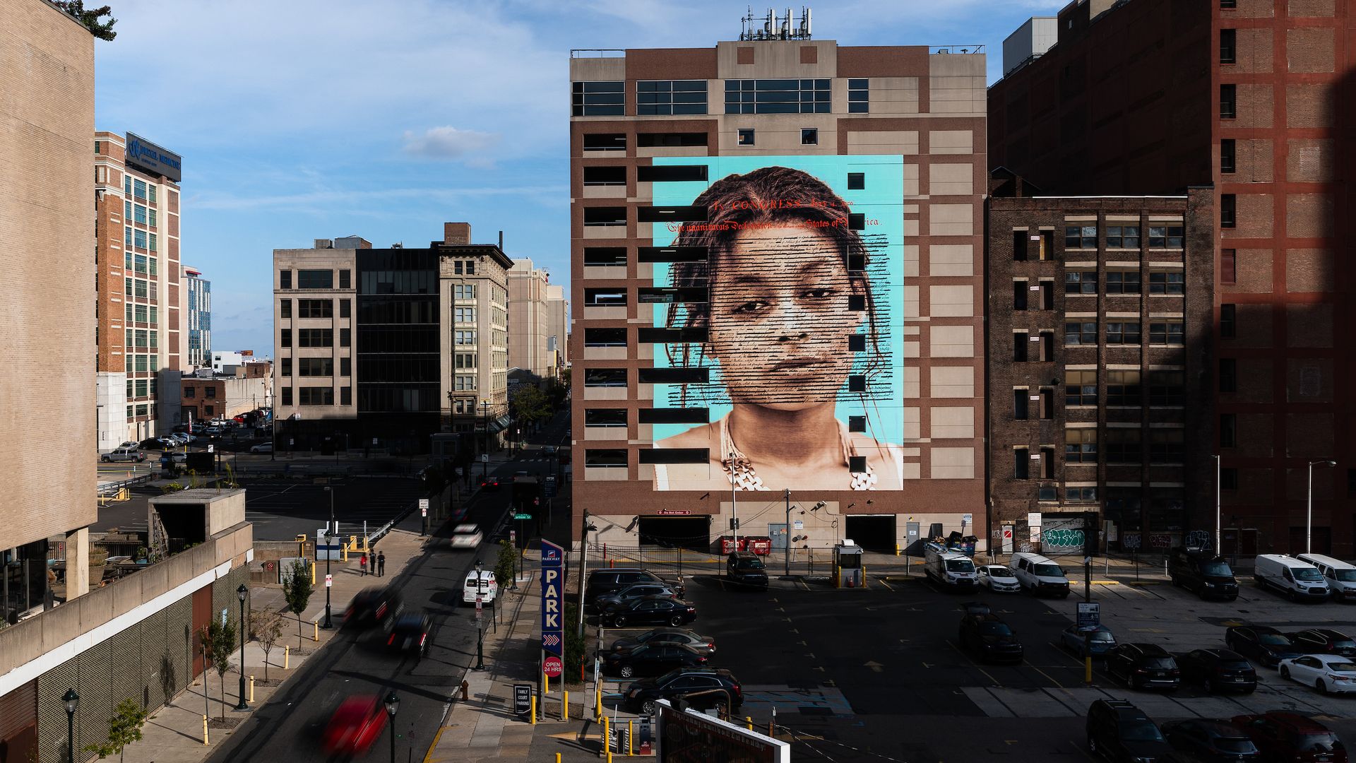 The mural “Declaration” is seen here on a building in North Philadelphia of a woman of color with the Declaration of Independence imposed over her face.