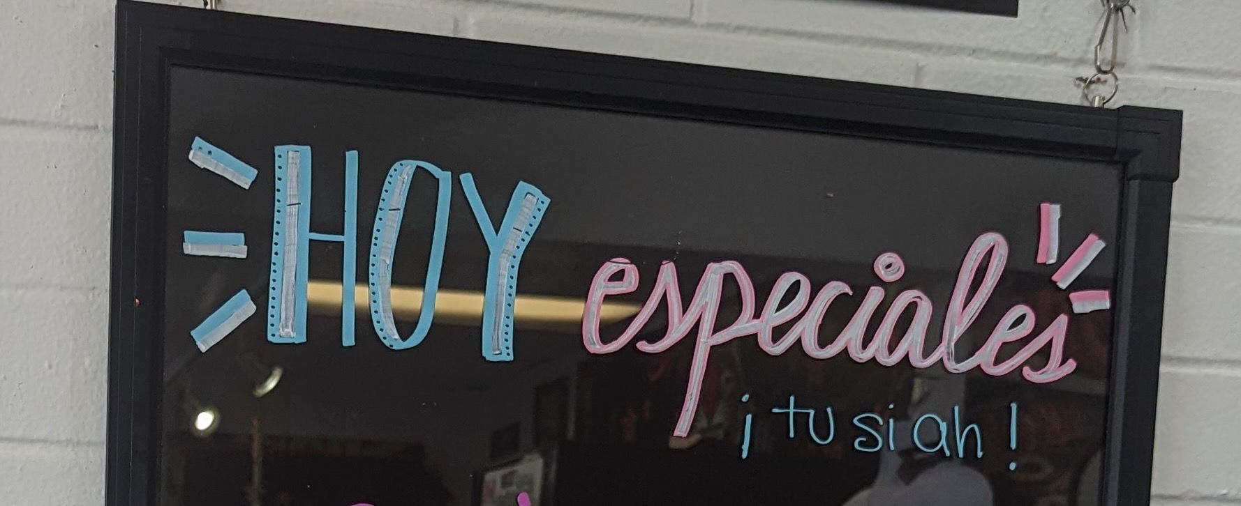A restaurant sign advertises "Today's specials" in Spanish, followed by "tu si ah," which is a Peruvian expression of approval and encouragement.