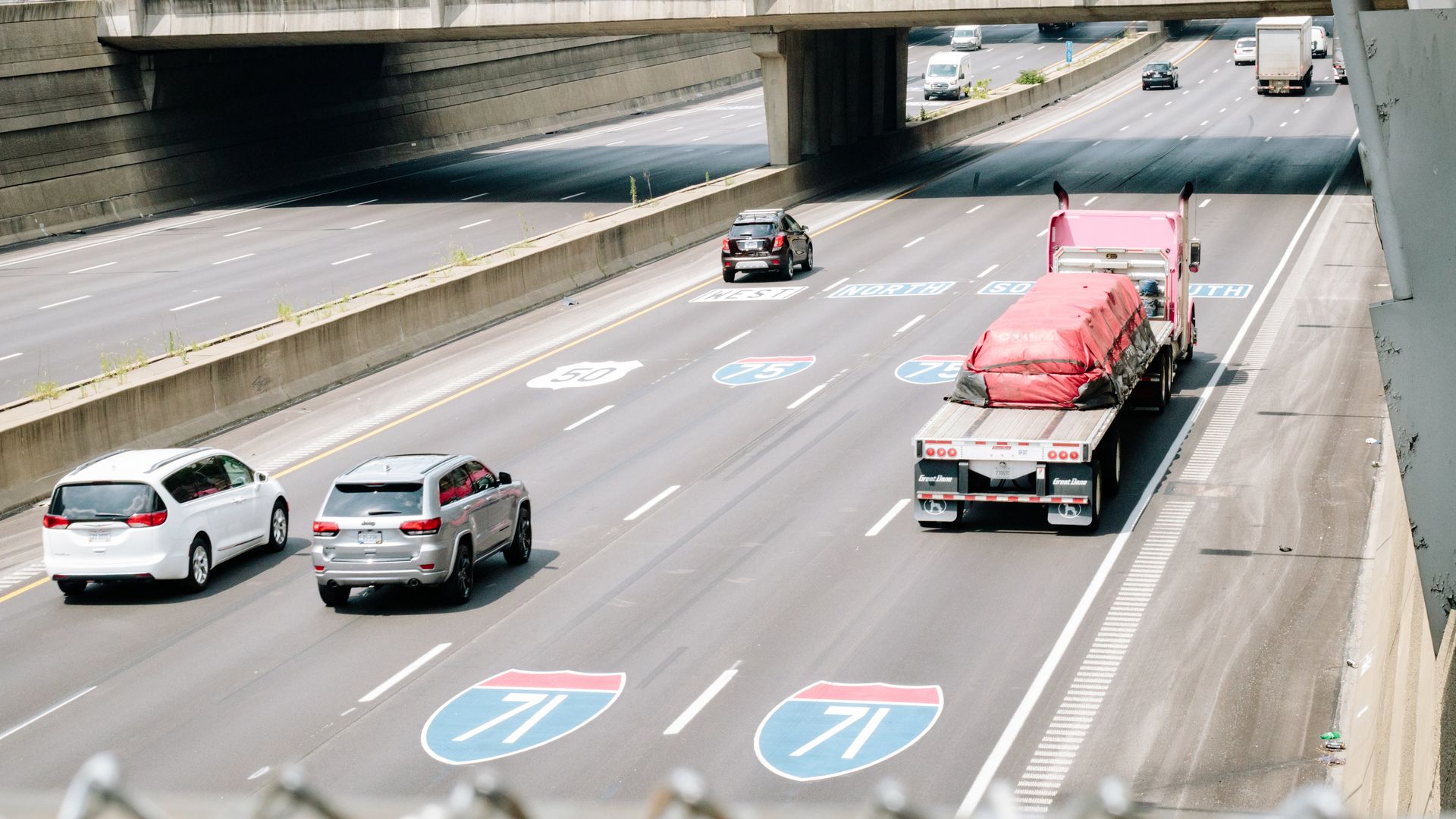 A stretch of highway with road numbers I-71 and I-75 painted on the ground.