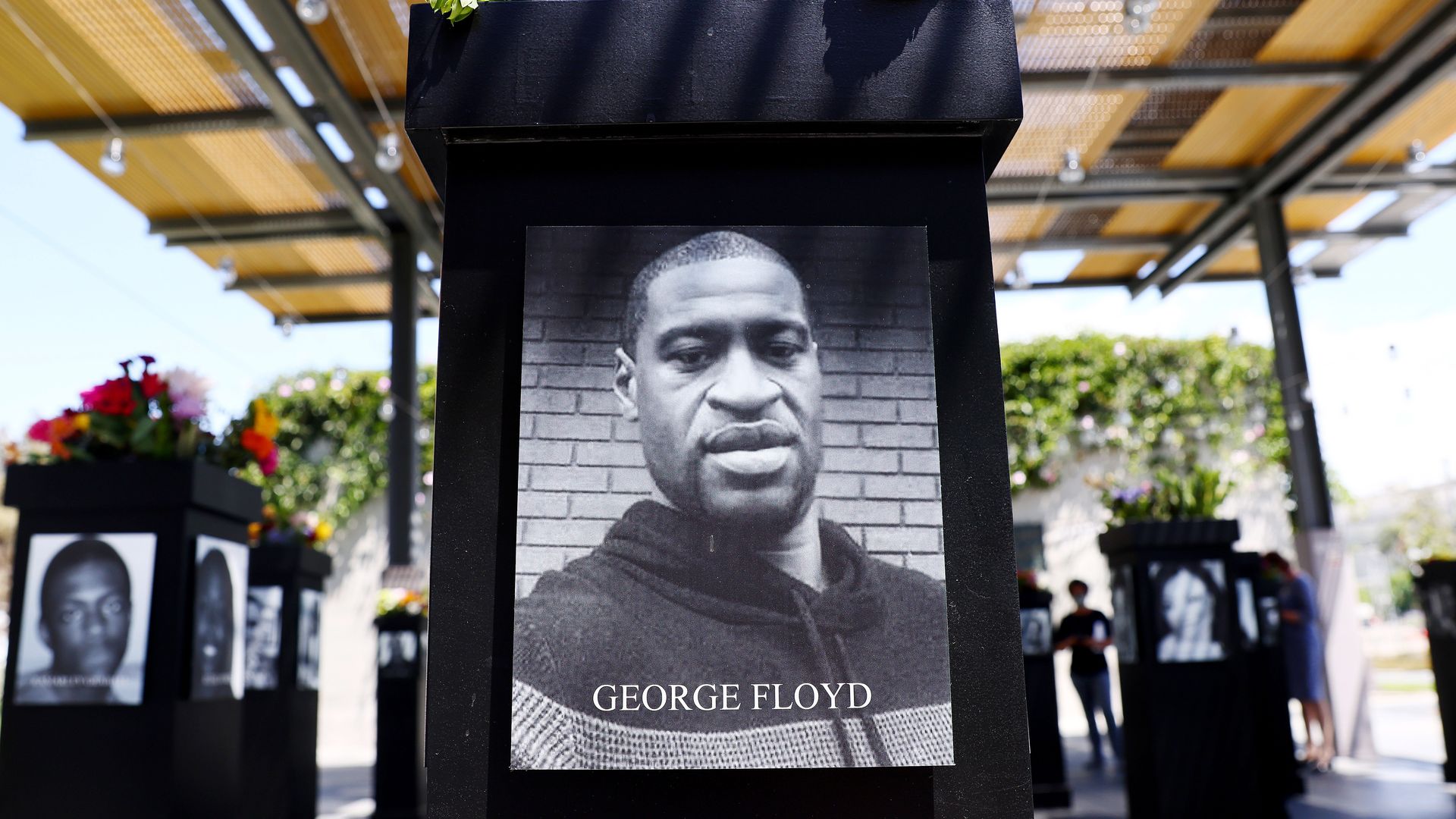 A photograph of George Floyd (C) is displayed along with other photographs at the Say Their Names memorial exhibit at Martin Luther King Jr. Promenade on July 20, 2021 in San Diego, Californi