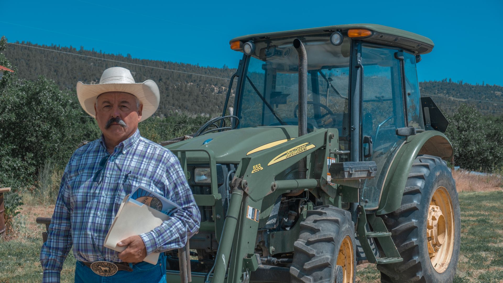 New Mexico rancher David Sanchez stands in front of a tractor in Canjilon, New Mexico.