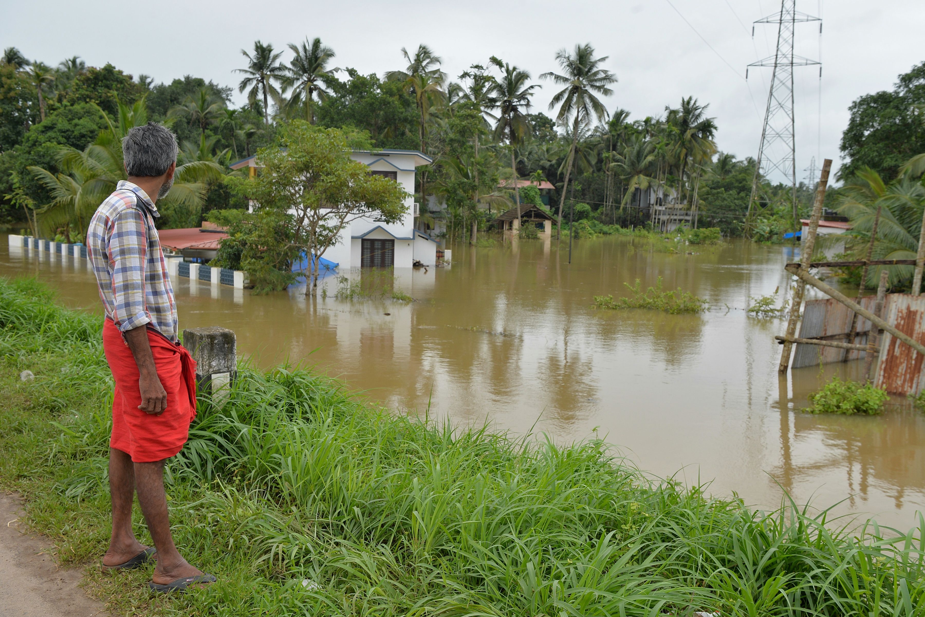 An Indian man watches marooned houses on the outskirts of Kozhikode district, in the south Indian state of Kerala. Photo: Manjunath Kiran/AFP/Getty Images
