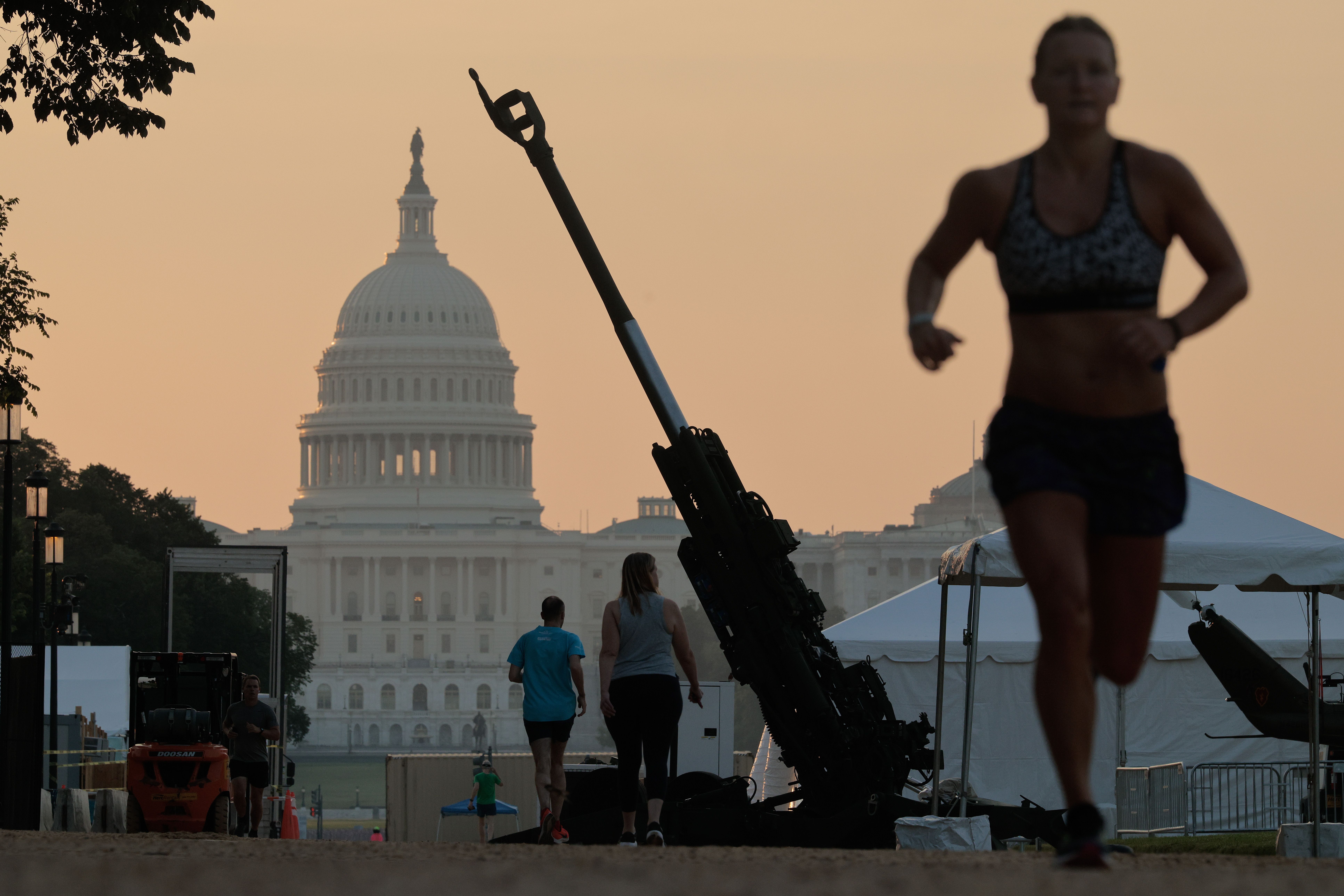 An image of a runner on Washington, D.C.'s National Mall, with the U.S. Capitol and a Army Howitzer in the background.