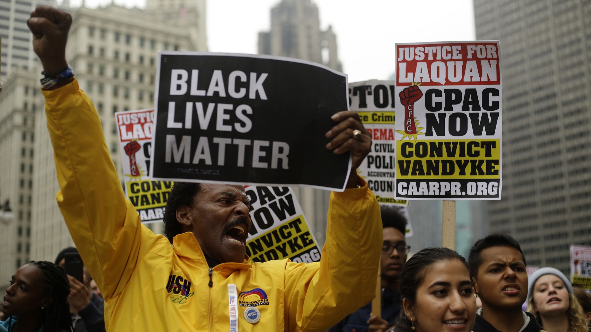 Protesters hold up a sign. One sign reads "Black lives matter"