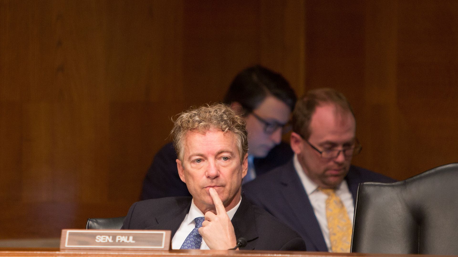 In this image, Senator Rand Paul sits behind his name plaque at a hearing.