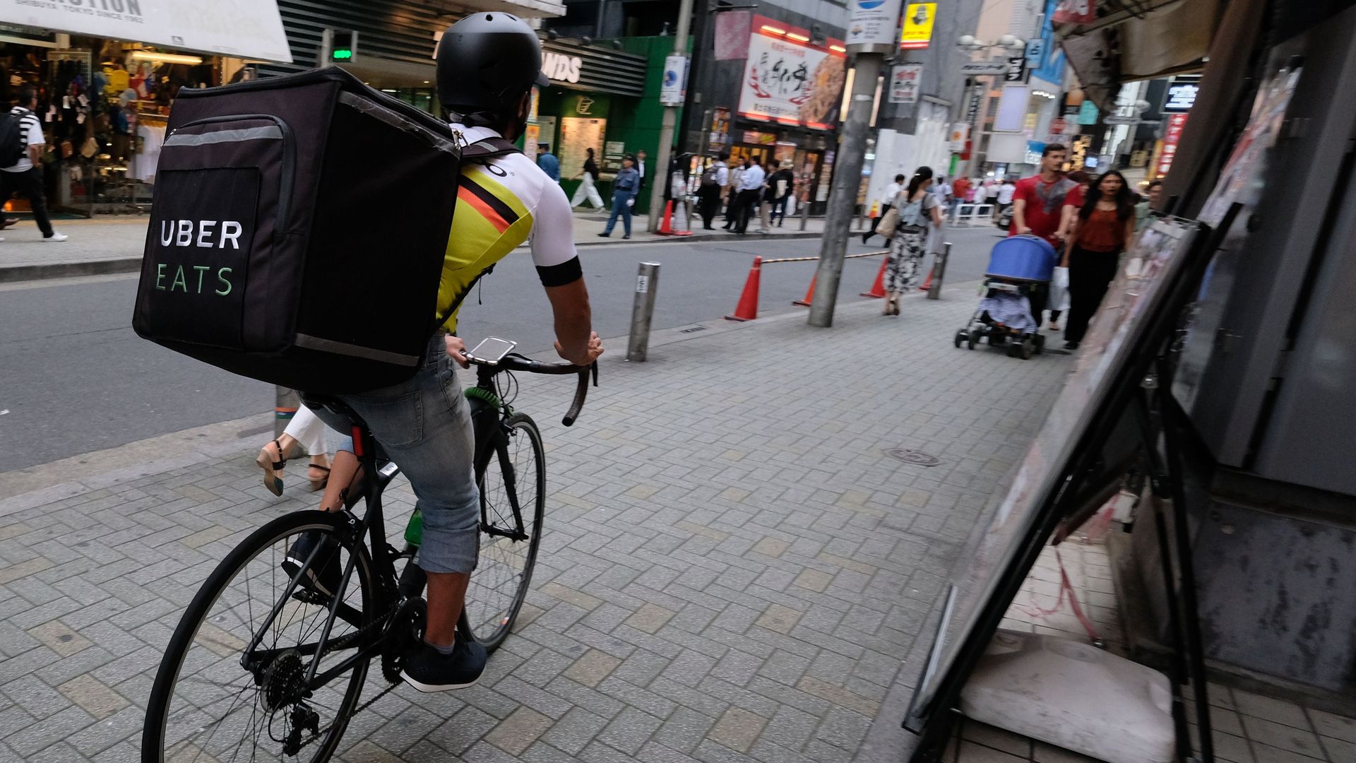 Man on bike delivering food with Uber Eats.