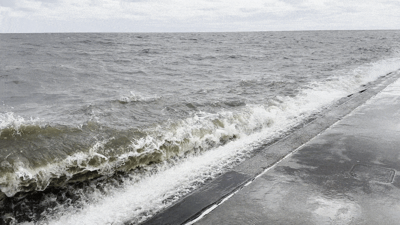 Image shows a wave crashing on a bulkhead.