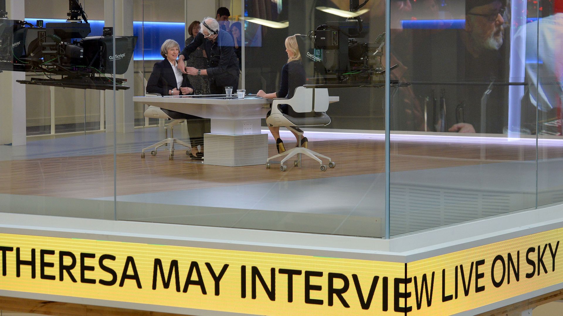 Theresa May sits across from a journalist on set