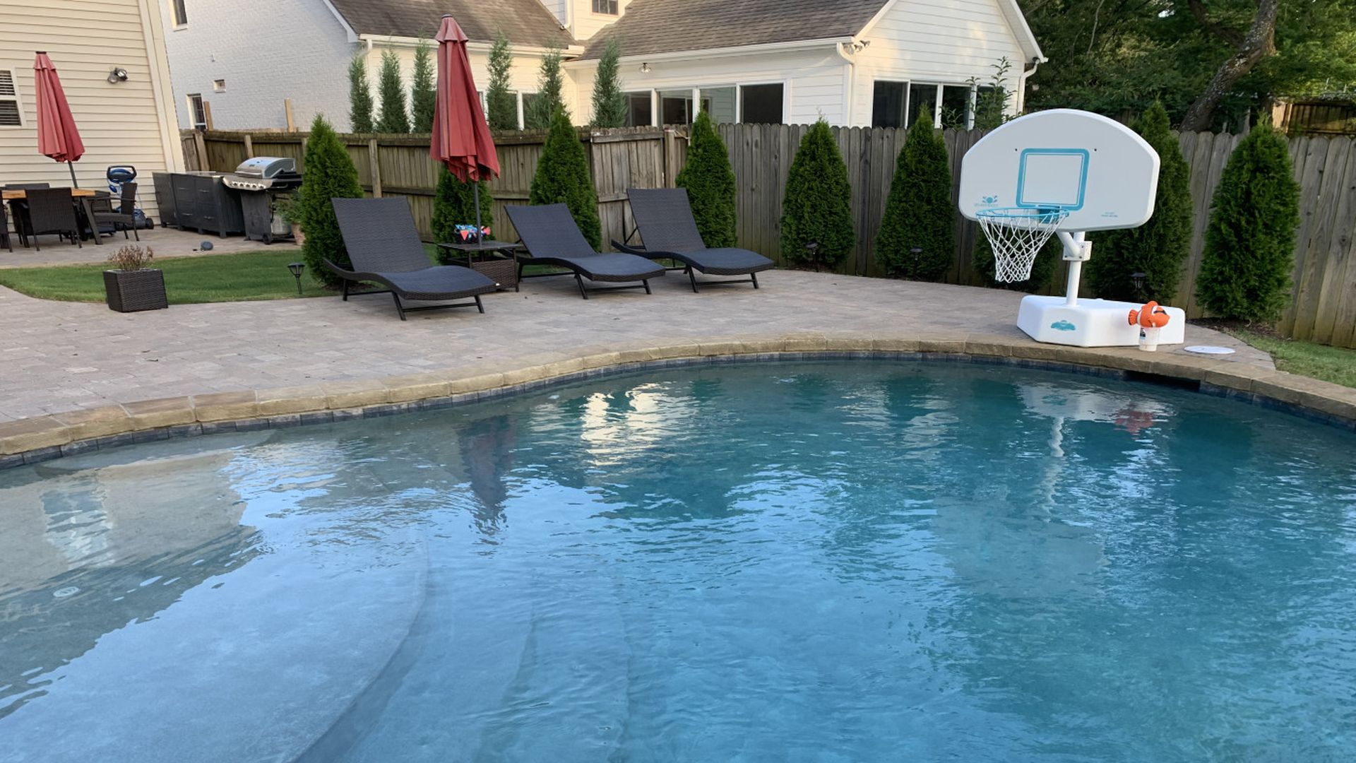 Backyard pool with basketball hoop