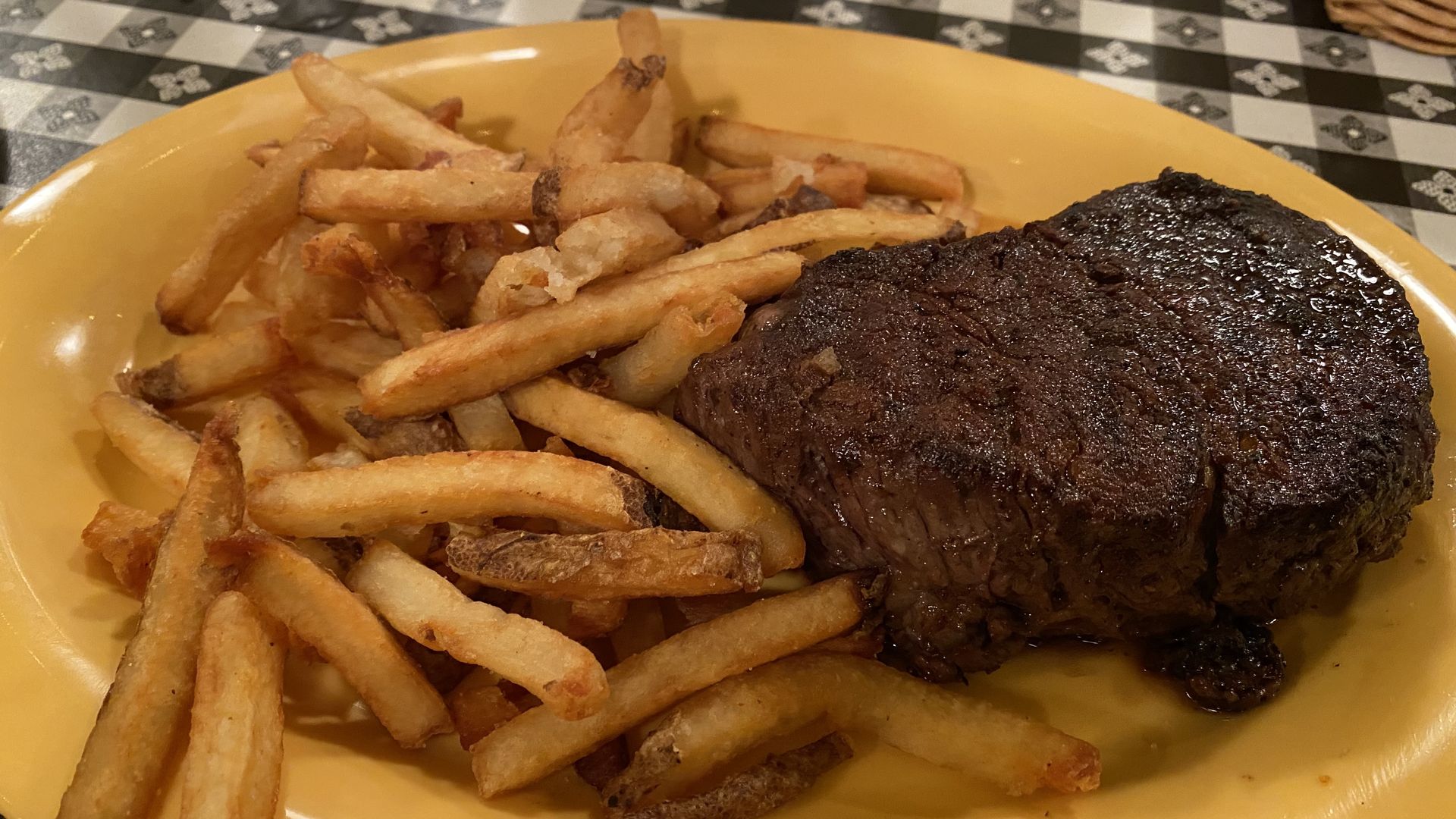 A plate with a steak and french fries. 