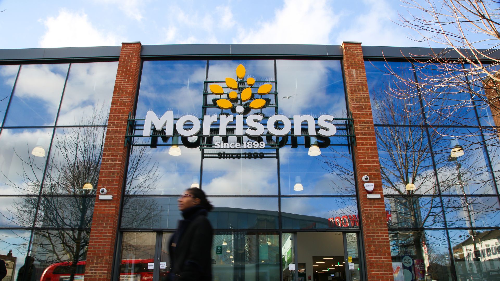A shopper walks past a branch of Morrison supermarket in north London