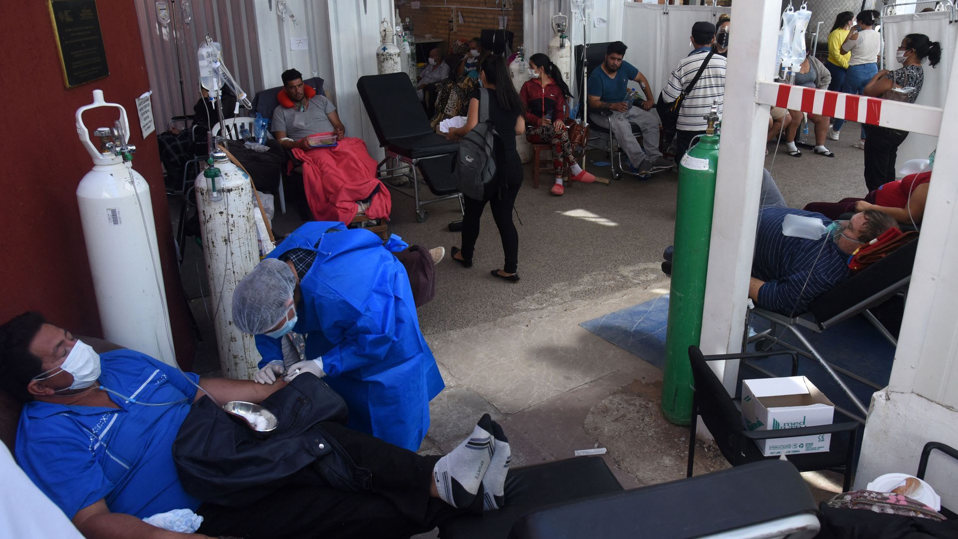 Patients with less severe COVID-19 cases in Paraguay are treated on May 1 in the corridor of a hospital that has run out of beds.