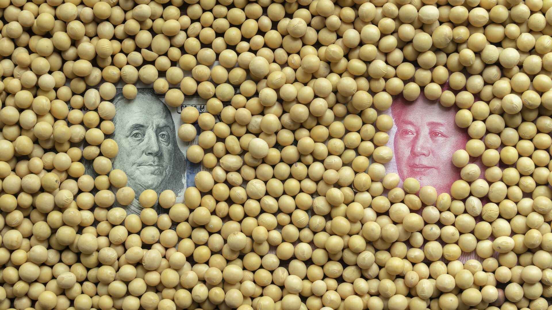 Soybeans covering U.S. dollar bill and China's RMB bill