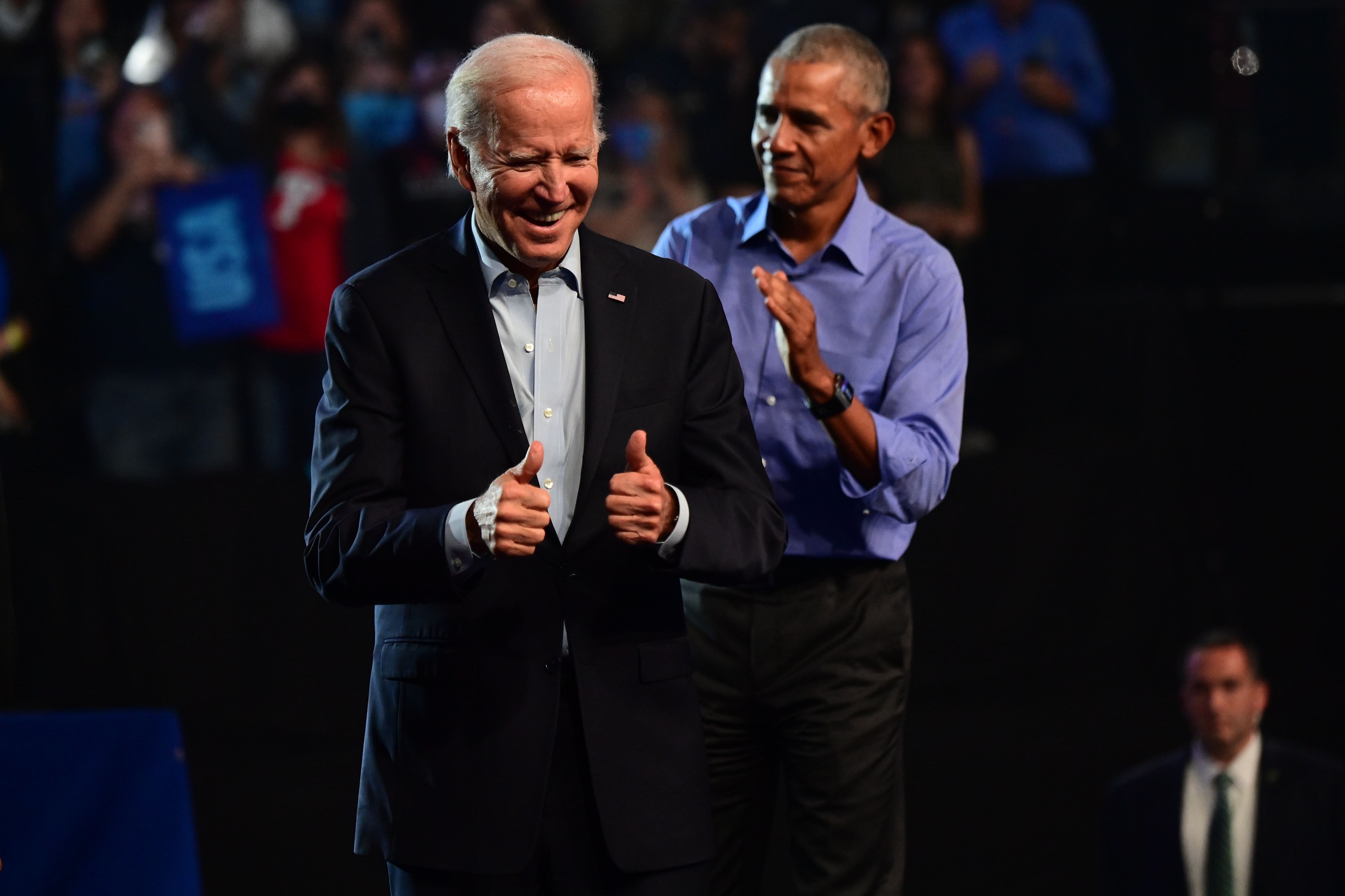 Biden and Obama on a stage, with Obama slightly behind Biden