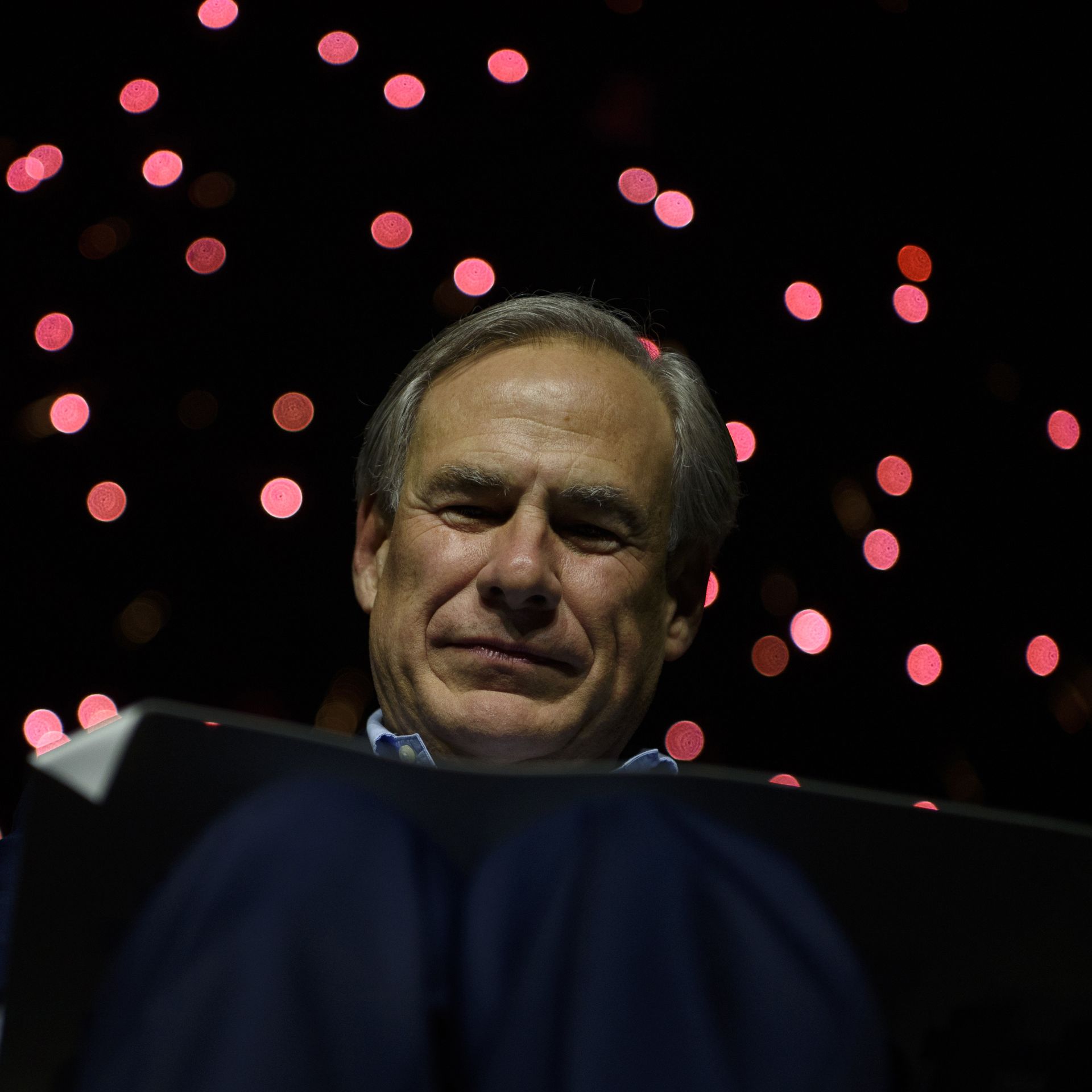 Texas Gov. Greg Abbott's face is visible behind a lectern 