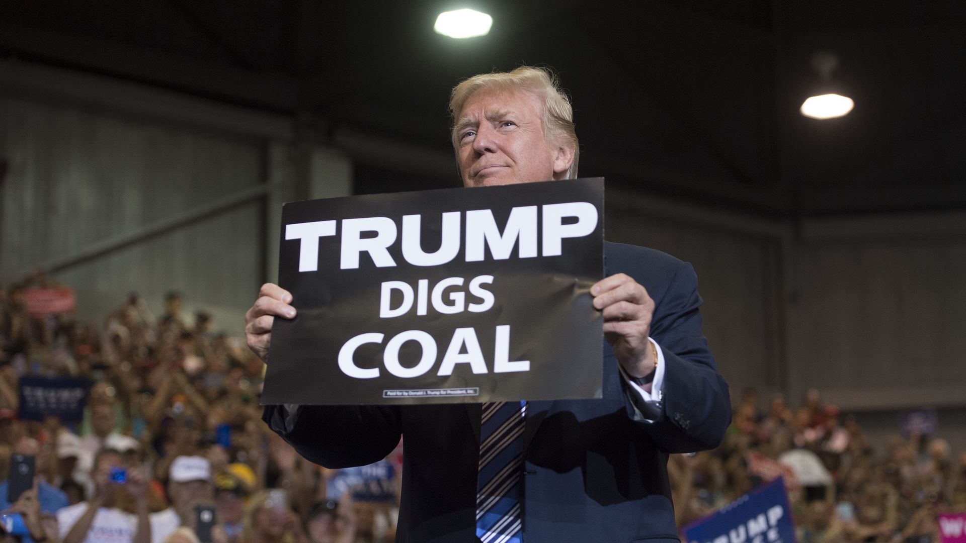 President Trump holding a "Trump digs coal" sign