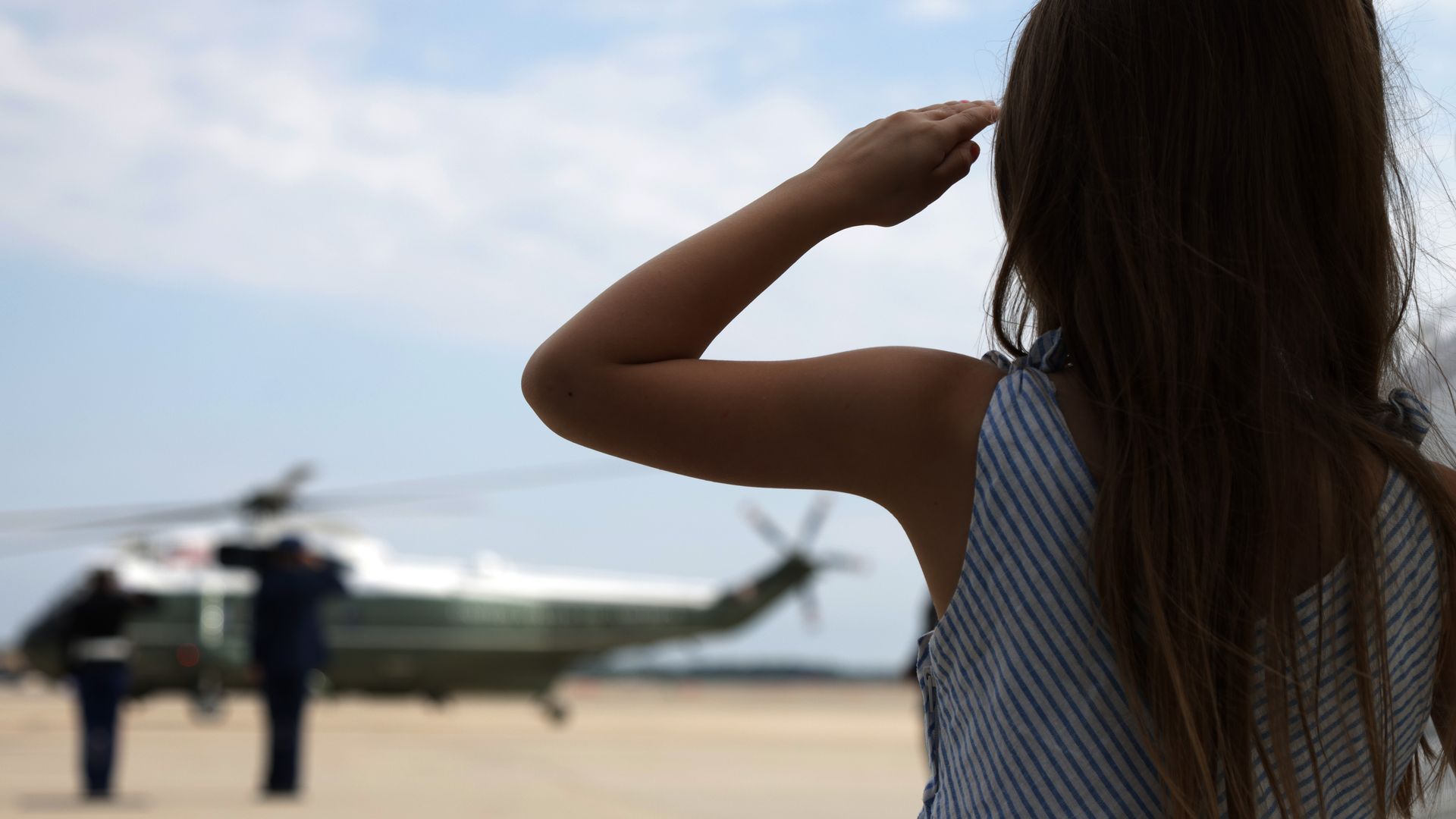 A young girl salutes Marine Two as Vice President Kamala Harris arrives at Joint Base Andrews.