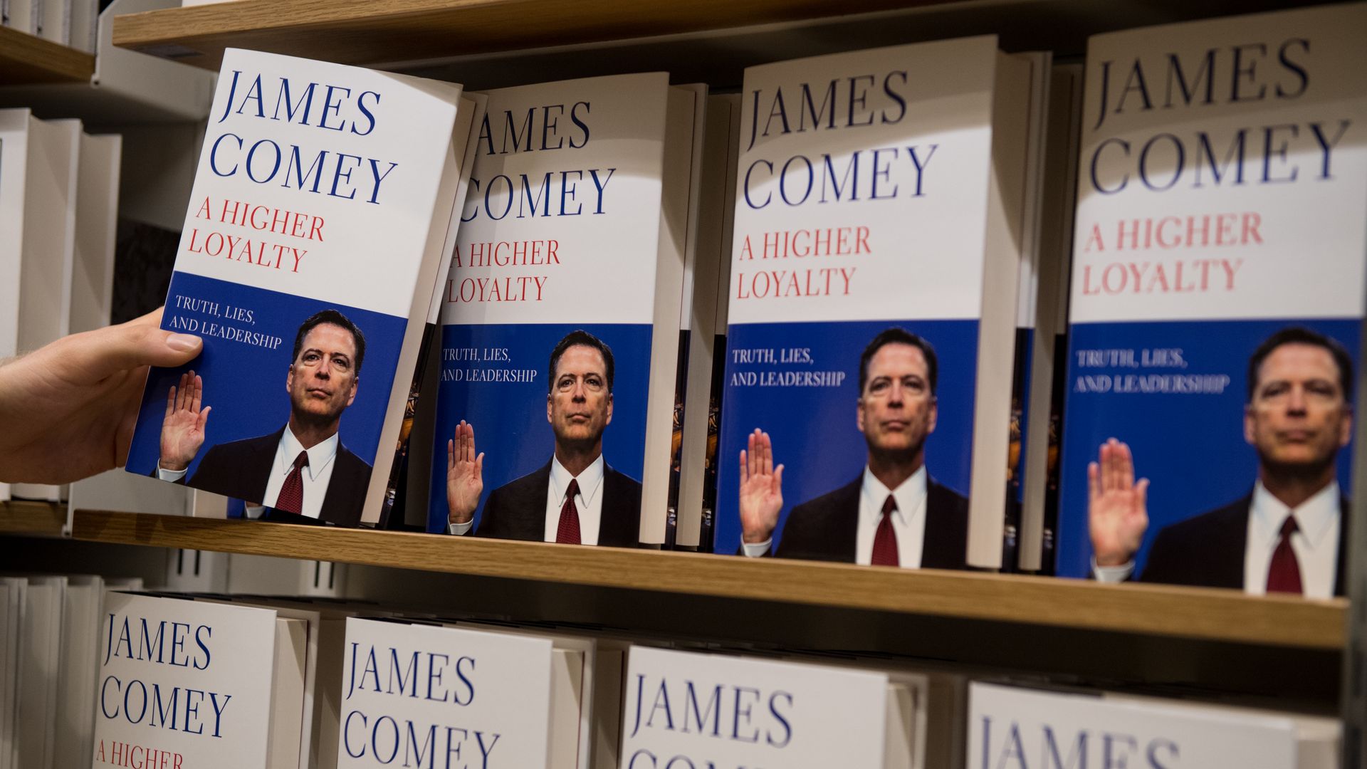 A customer reaches for Comey's book in a store