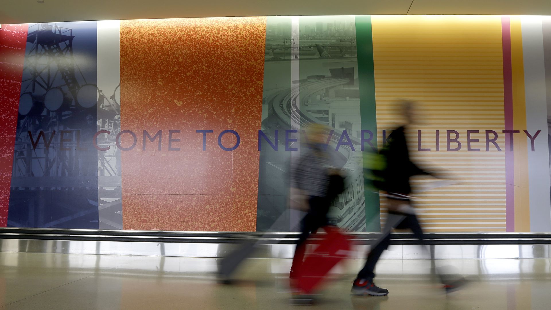 Travelers walk with their luggage at Newark Liberty International Airport.