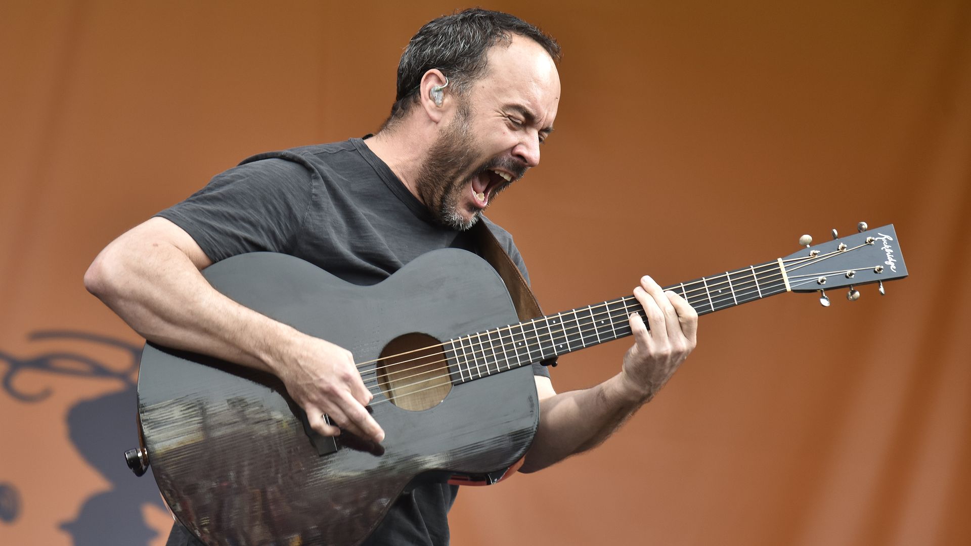 Dave Matthews plays his guitar on a Jazz Fest stage.