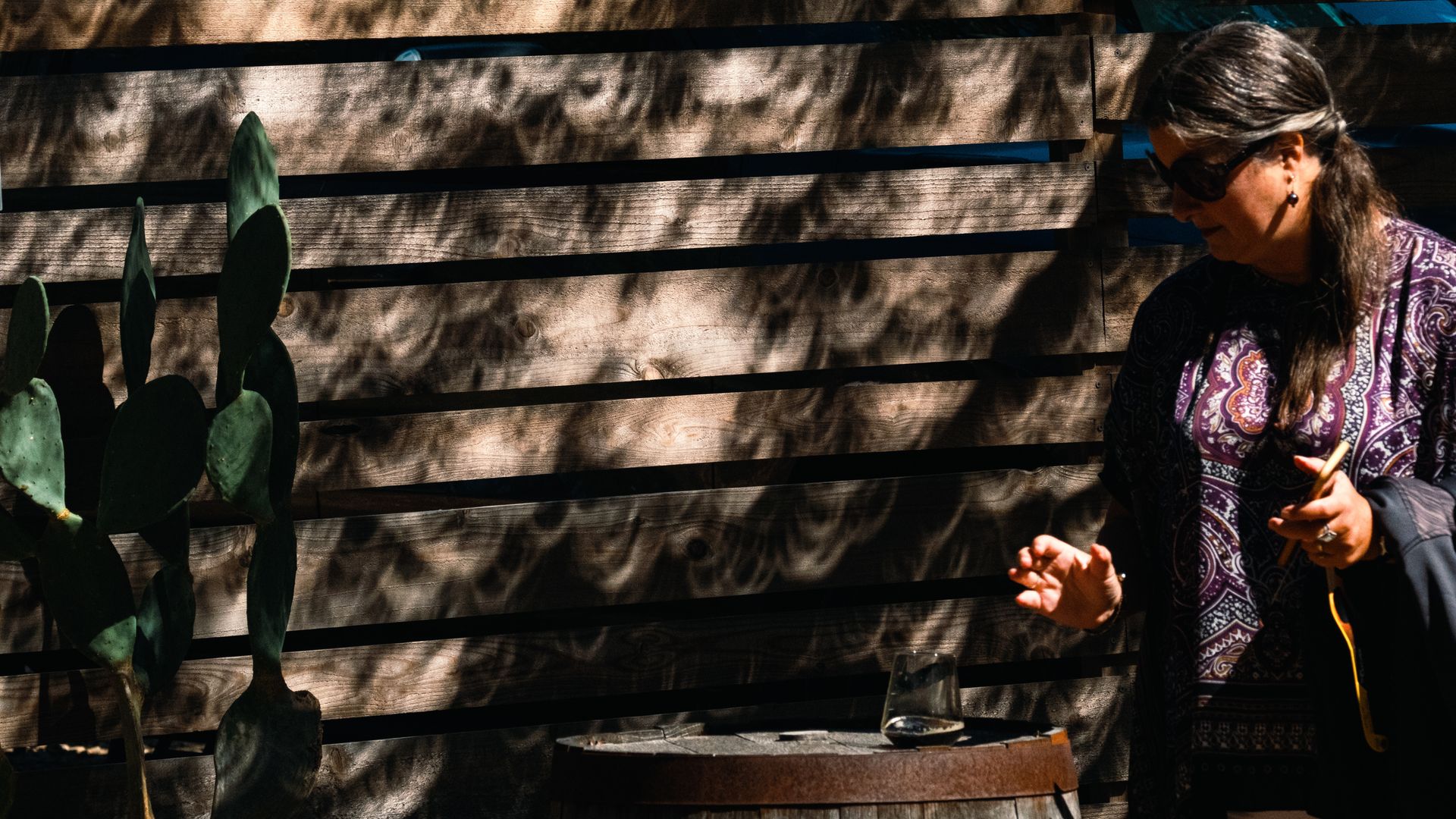 A woman next to a beer and a cactus, with solar eclipse shadows over her, in the Texas Hill Country in October 2023.