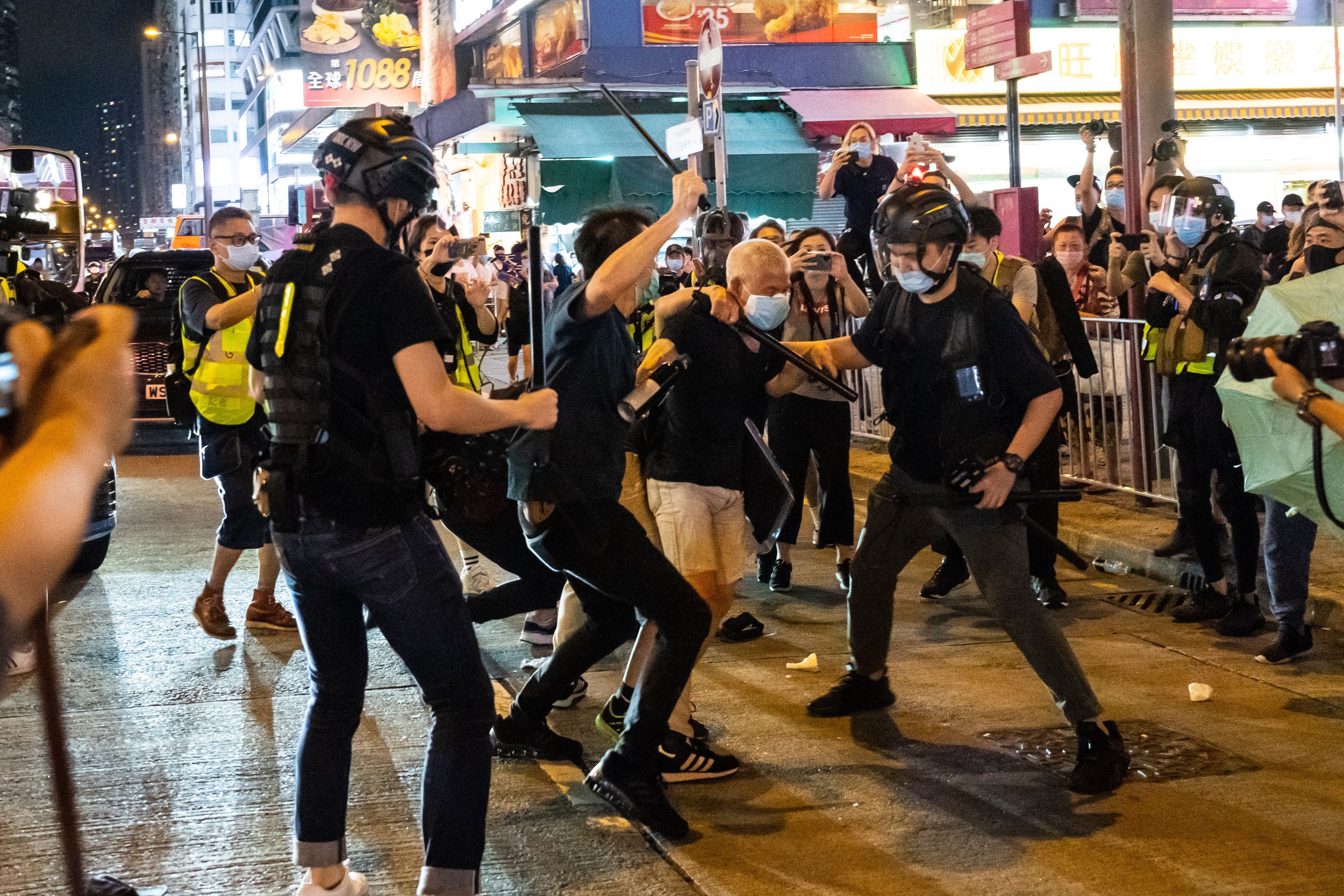 Men in helmets surrounded another while beating him, all wearing face masks