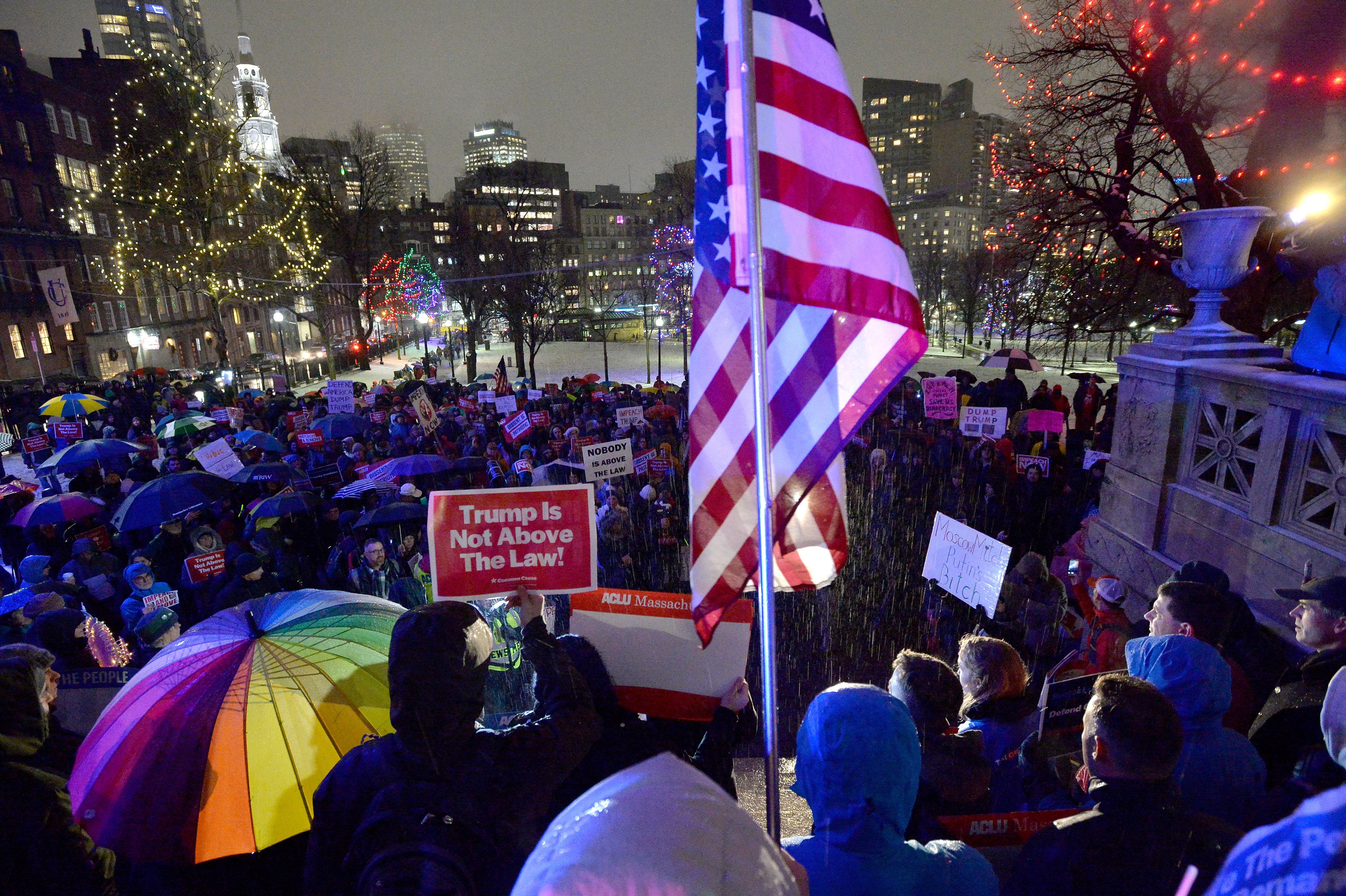 Protesters hold an American Flag while they gathered at Boston Common during a rally where over a thousand people calling for the impeachment of PresidentTrump in Boston