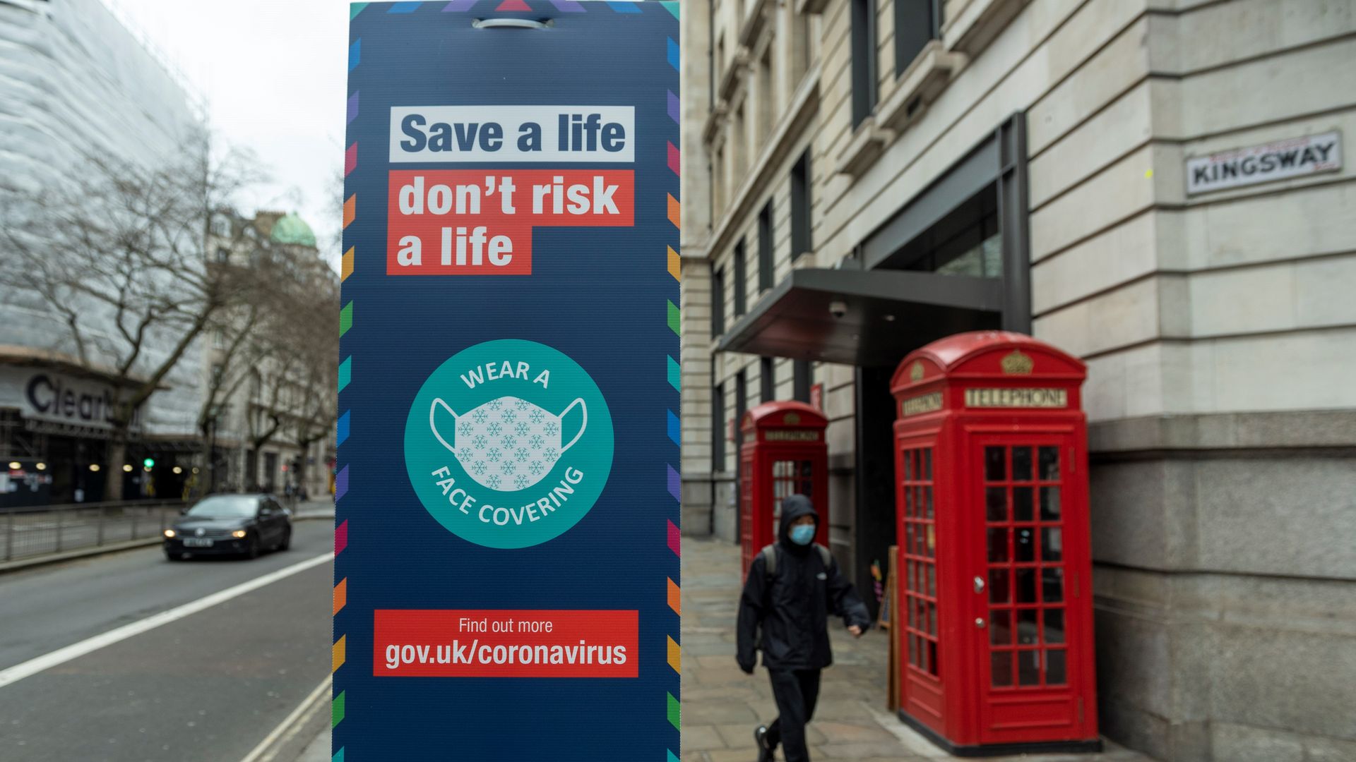 Photo of a street sign that says "Save a life, don't risk a life. Wear a face covering"