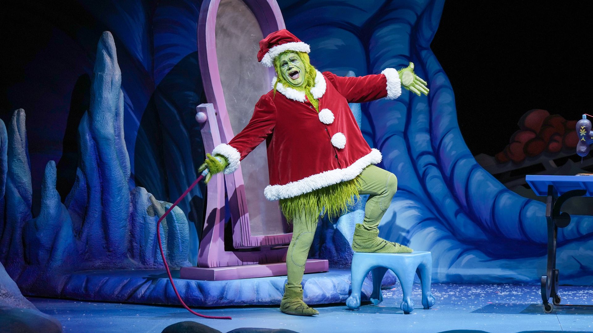 A photo of The Grinch with his arms