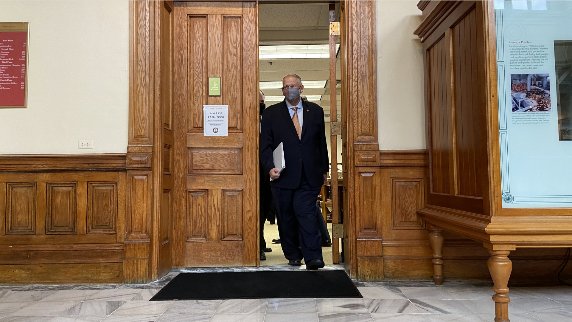 Georgia House Speaker David Ralston, wearing a mask and dark suit, walks out of a conference room at the state Capitol