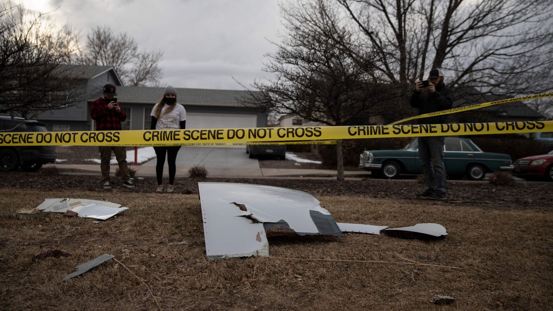 Residents take pictures of debris fallen from a United Airlines airplane's engine on the neighborhood of Broomfield, outside Denver, Colorado, on February 20