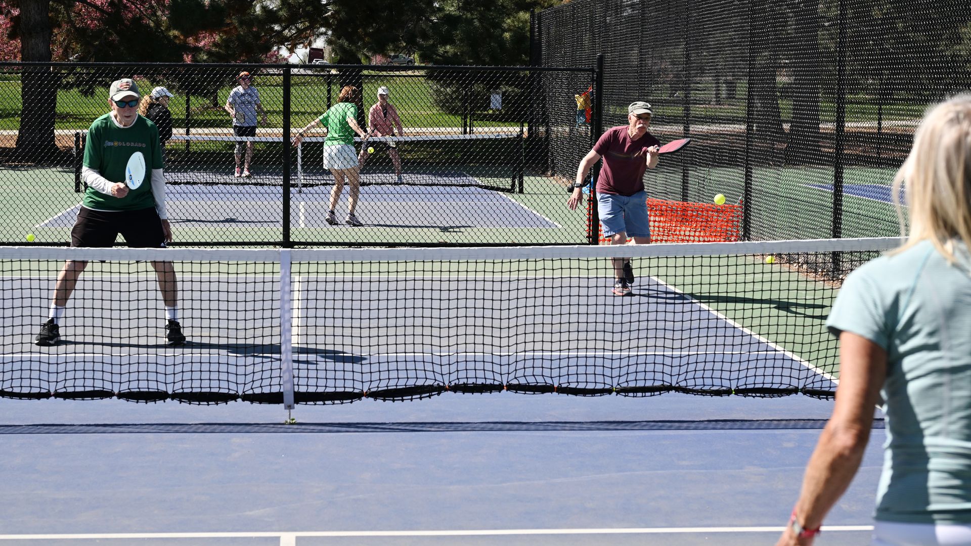 Photo shows players on a pickleball court