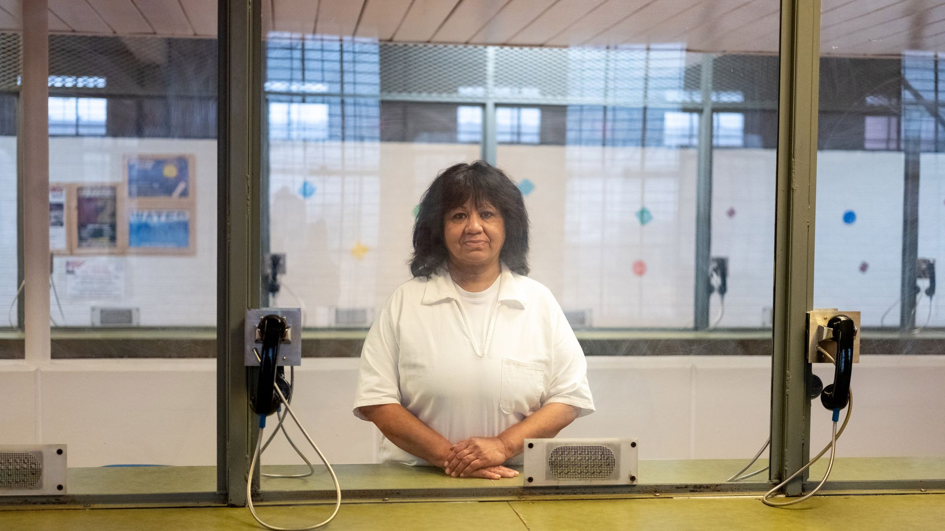 Death row inmate Melissa Lucio stands behind a glass window while in prison 