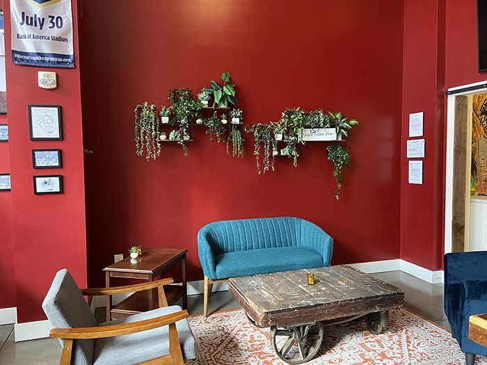 A plant wall above couches in the corner. 