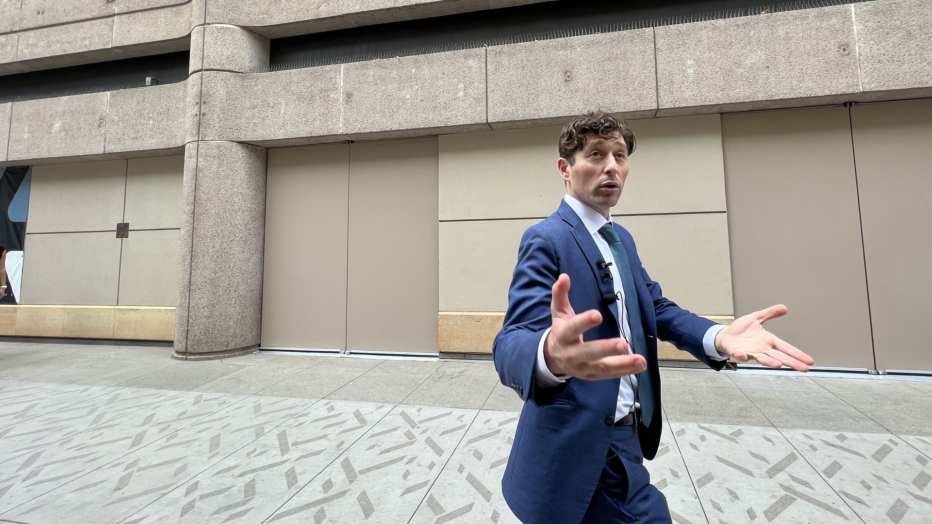 A man gestures as he walks down a street