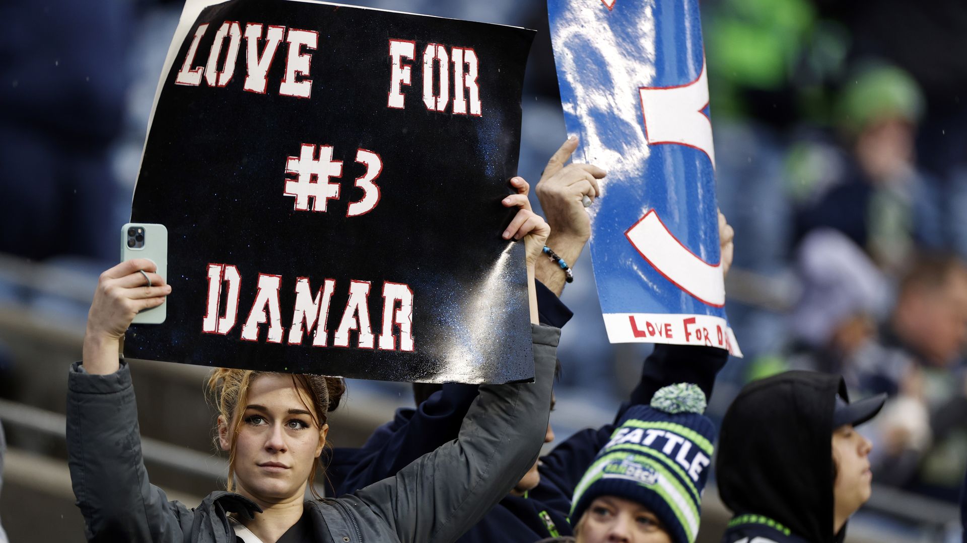 Seattle Seahawks fans hold signs in honor of Damar Hamlin