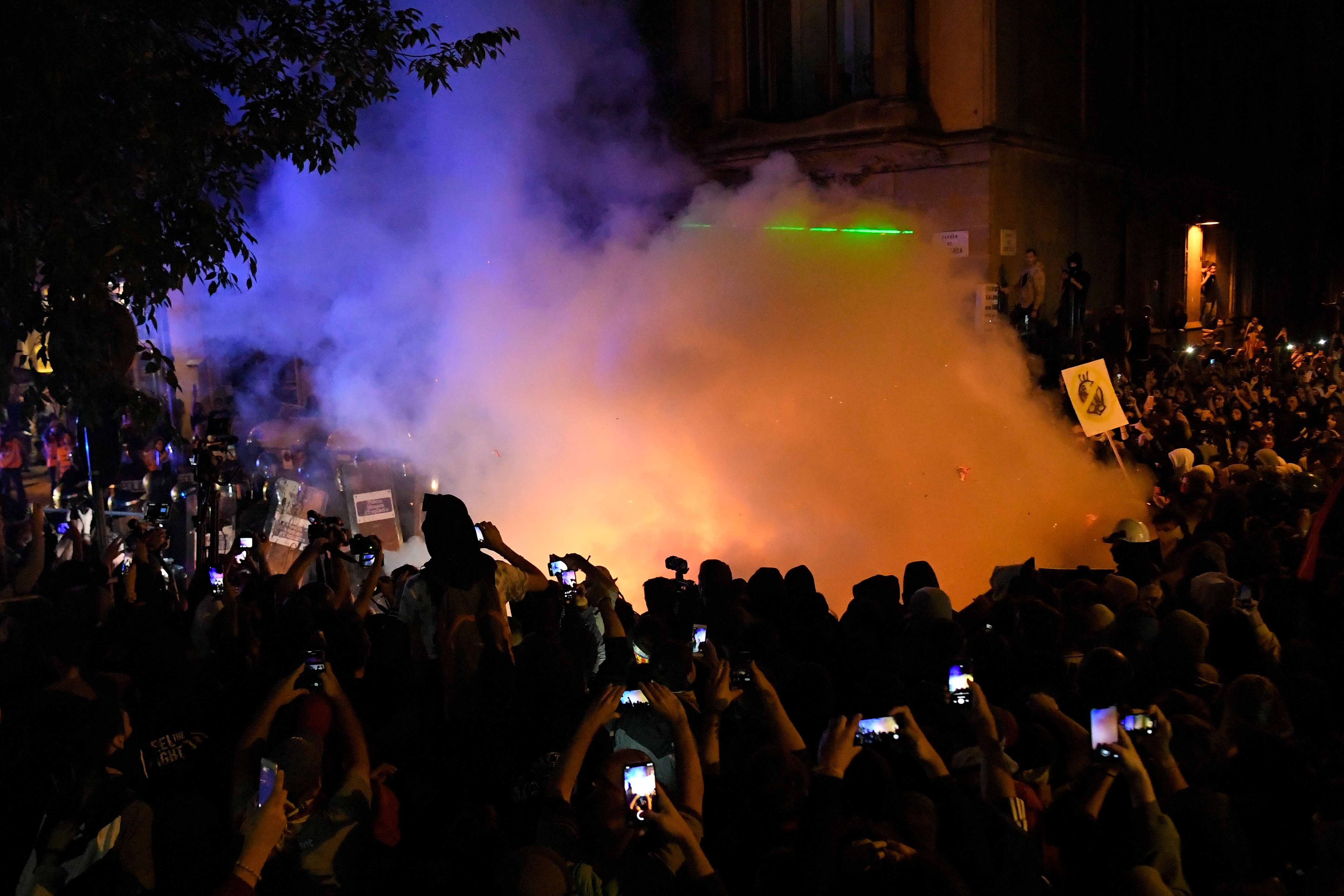 Protesters film a fire outside the Spanish Government Delegation. 