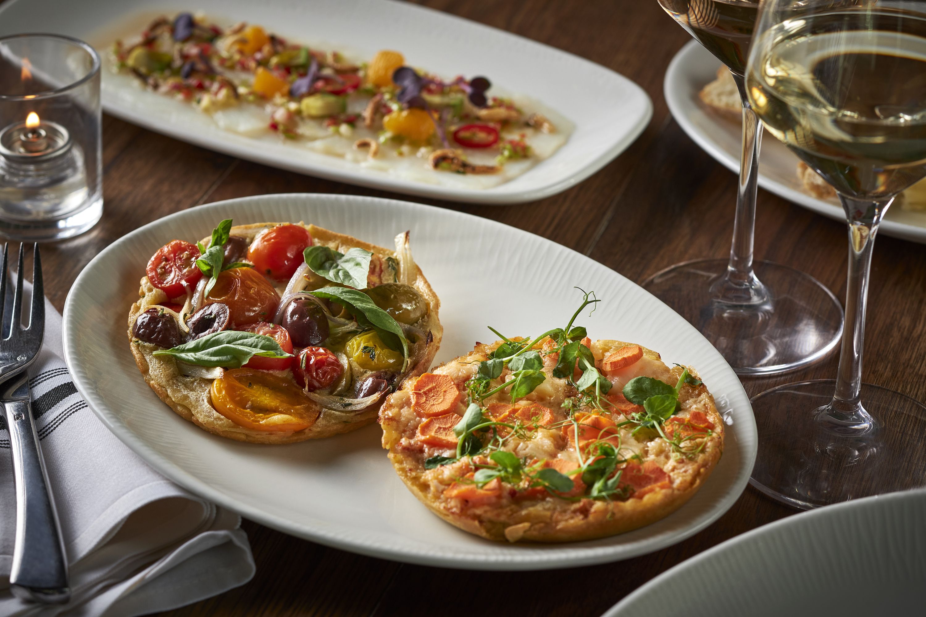 Mediterranean socca flatbreads topped with tomato and olives or lobster