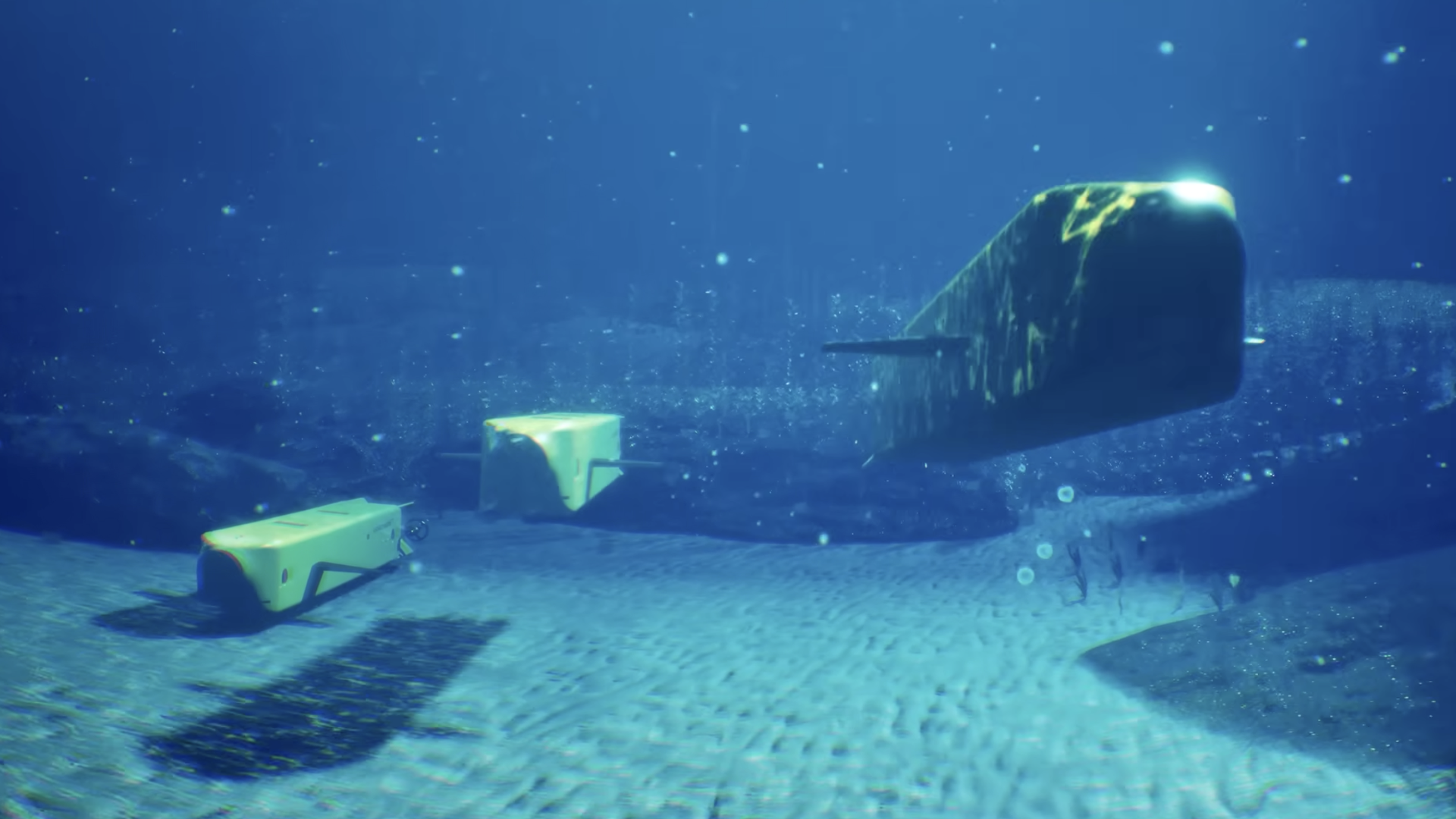 Three yellow underwater autonomous vehicles operating on the ocean floor with a blue watery background and bubbles rising around them.