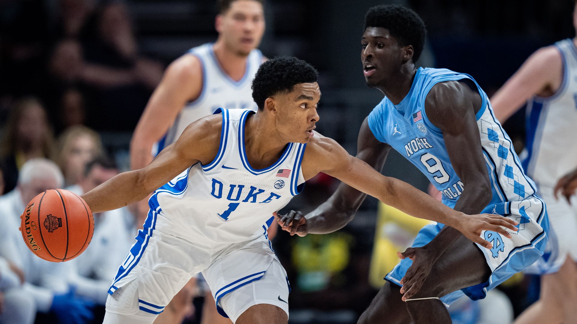 CHARLOTTE, NORTH CAROLINA - MARCH 14: Caleb Foster #1 of the Duke Blue Devils brings the ball up court while guarded by Drake Powell #9 of the North Carolina Tar Heels in the first half during the semifinal round of the ACC men's basketball tournament at Spectrum Center on March 14, 2025 in Charlott
