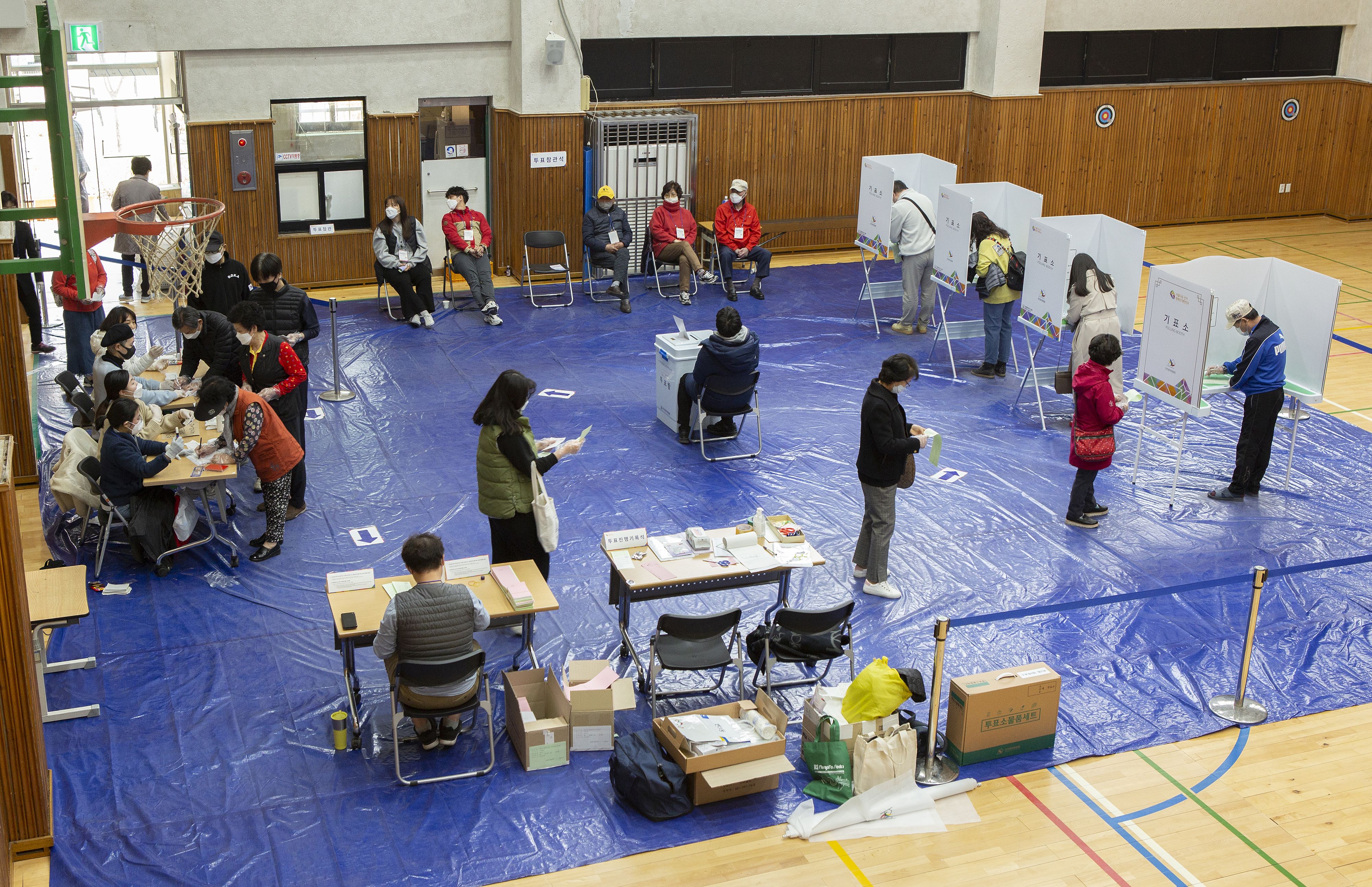 In this image, voters wait in line in a gym 