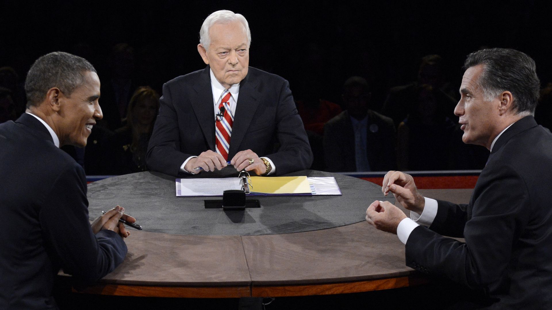 U.S. President Barack Obama (L) sits across from Republican presidential candidate Mitt Romney with Bob Schieffer between them as a debate moderator 