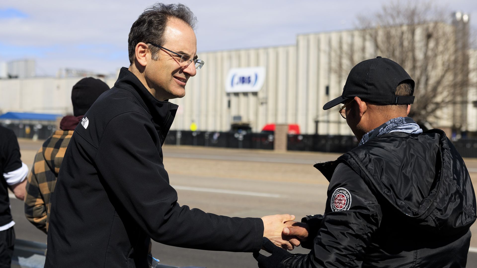 Colorado Attorney General Phil Weiser shakes hands with people picketing outside of the JBS Foods meatpacking plant on March 16 in Greeley. Photo: Michael Ciaglo/Getty Images