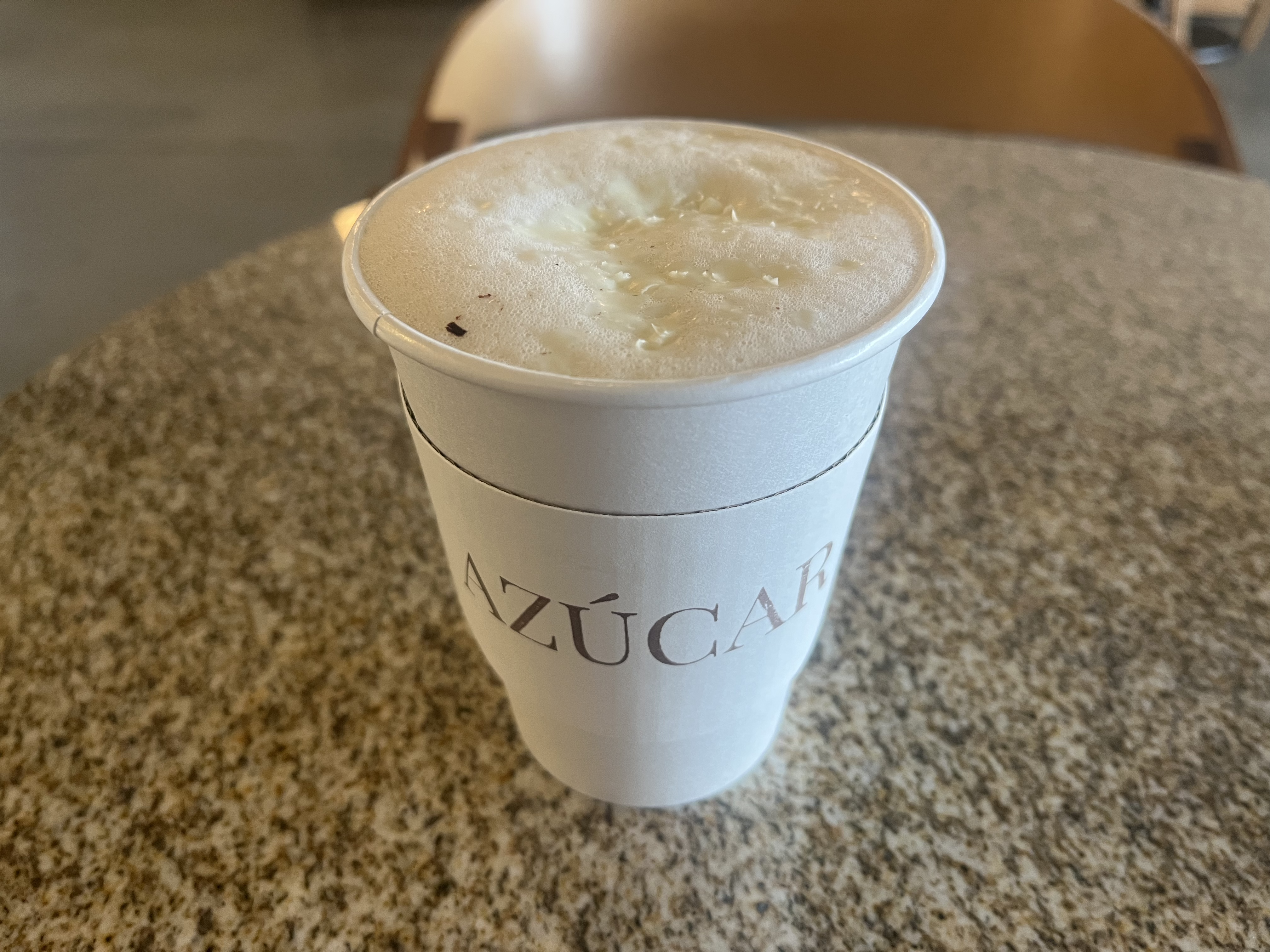 A to-go cup of coffee on a counter top.