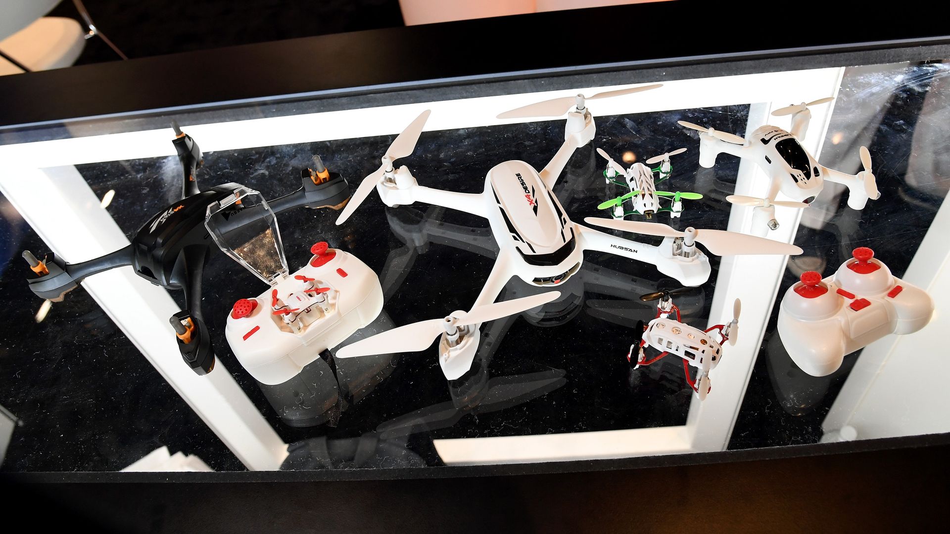 A table with remote controlled drones on them.