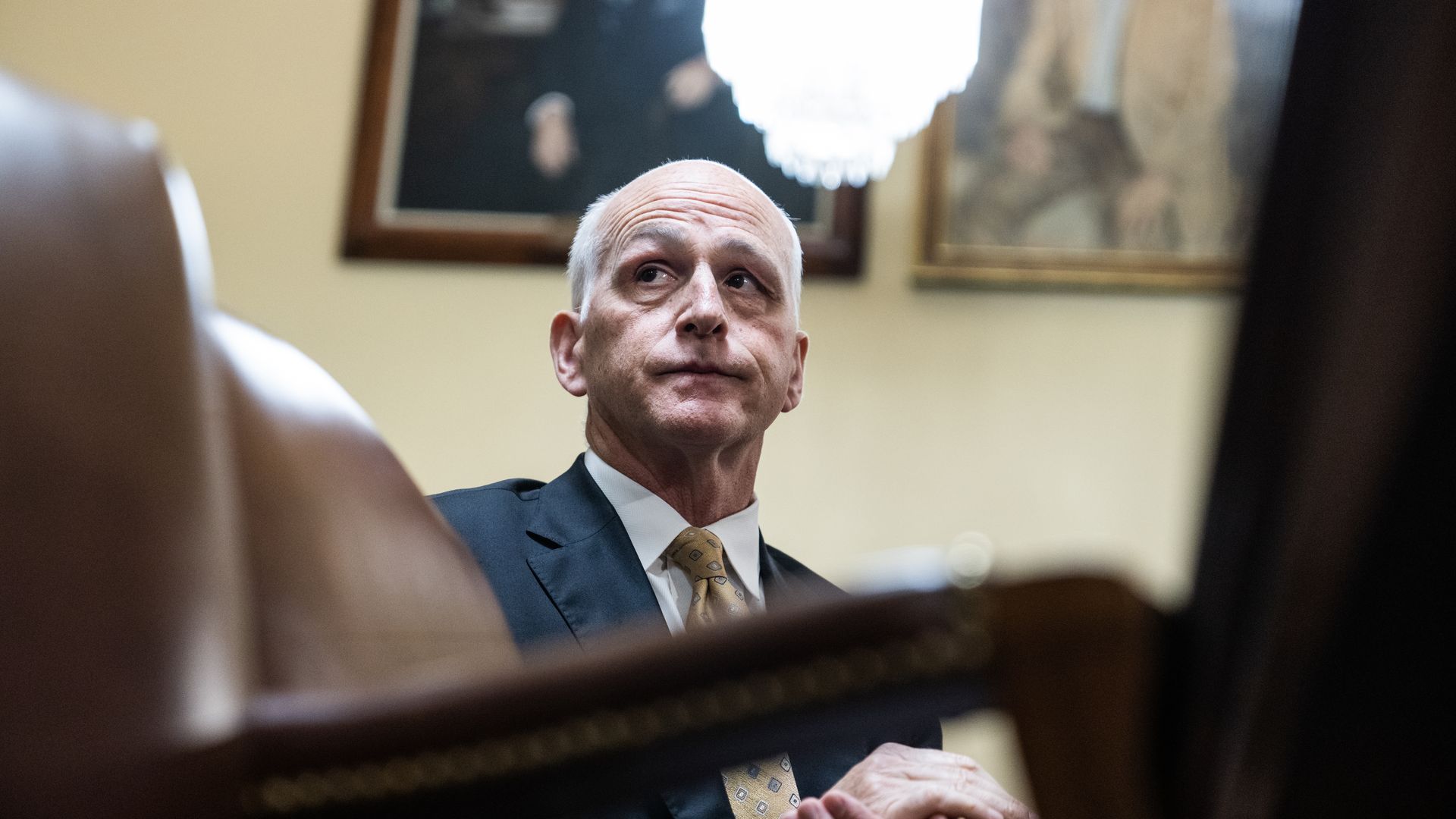 Rep. Adam Smith, wearing a blue suit in front of a cream colored wall.