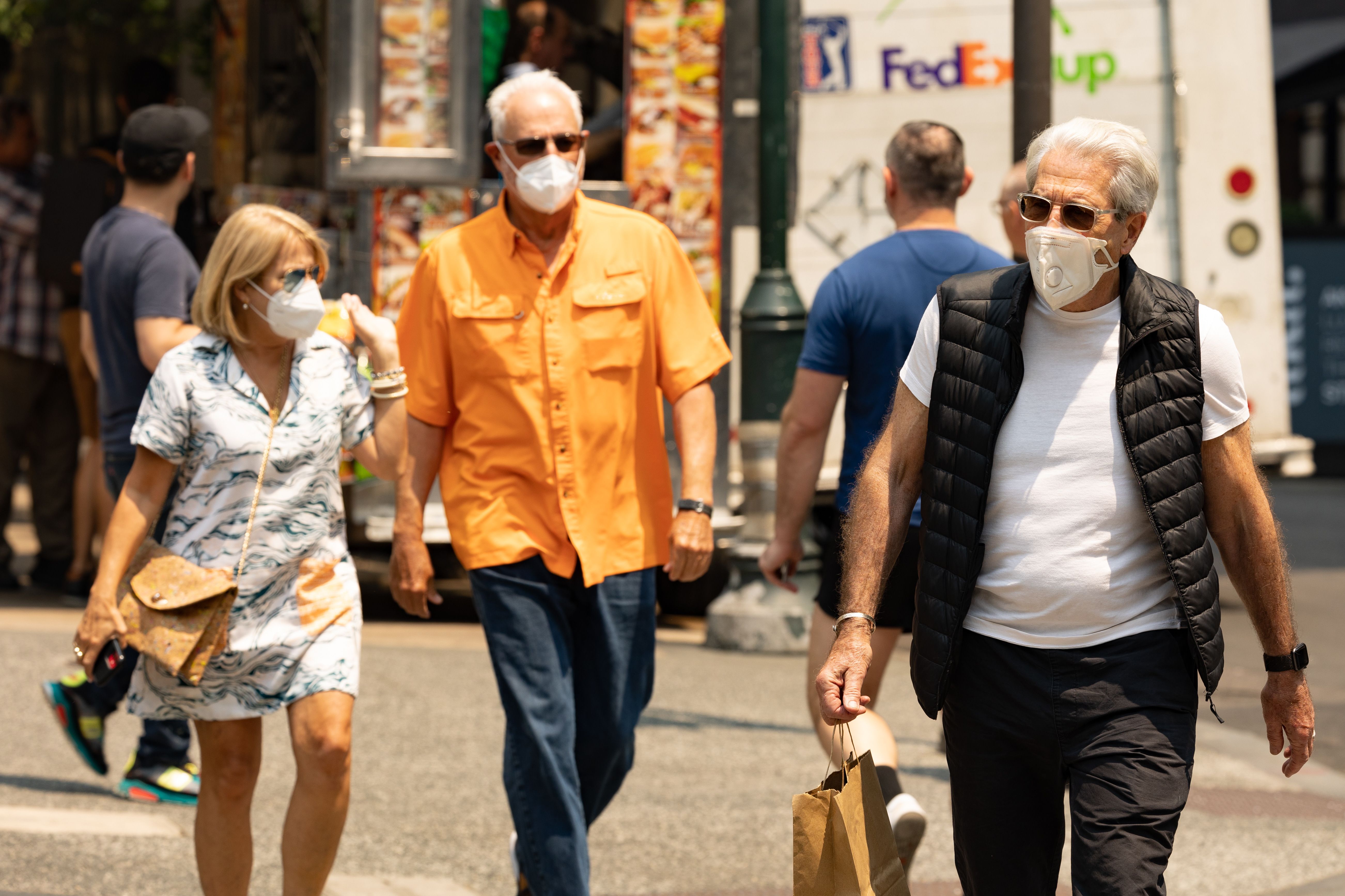 Pedestrians wear masks to protect themselves from wildfire smoke.