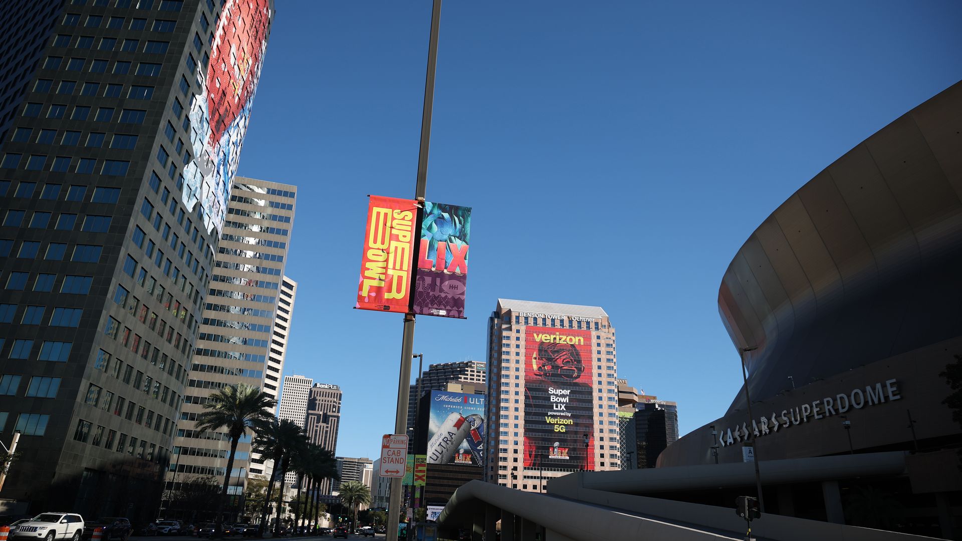 Skyscrapers and a lamp post with a Super Bowl LIX sign on it are seen next to the Caesars Superdome in New Orleans.