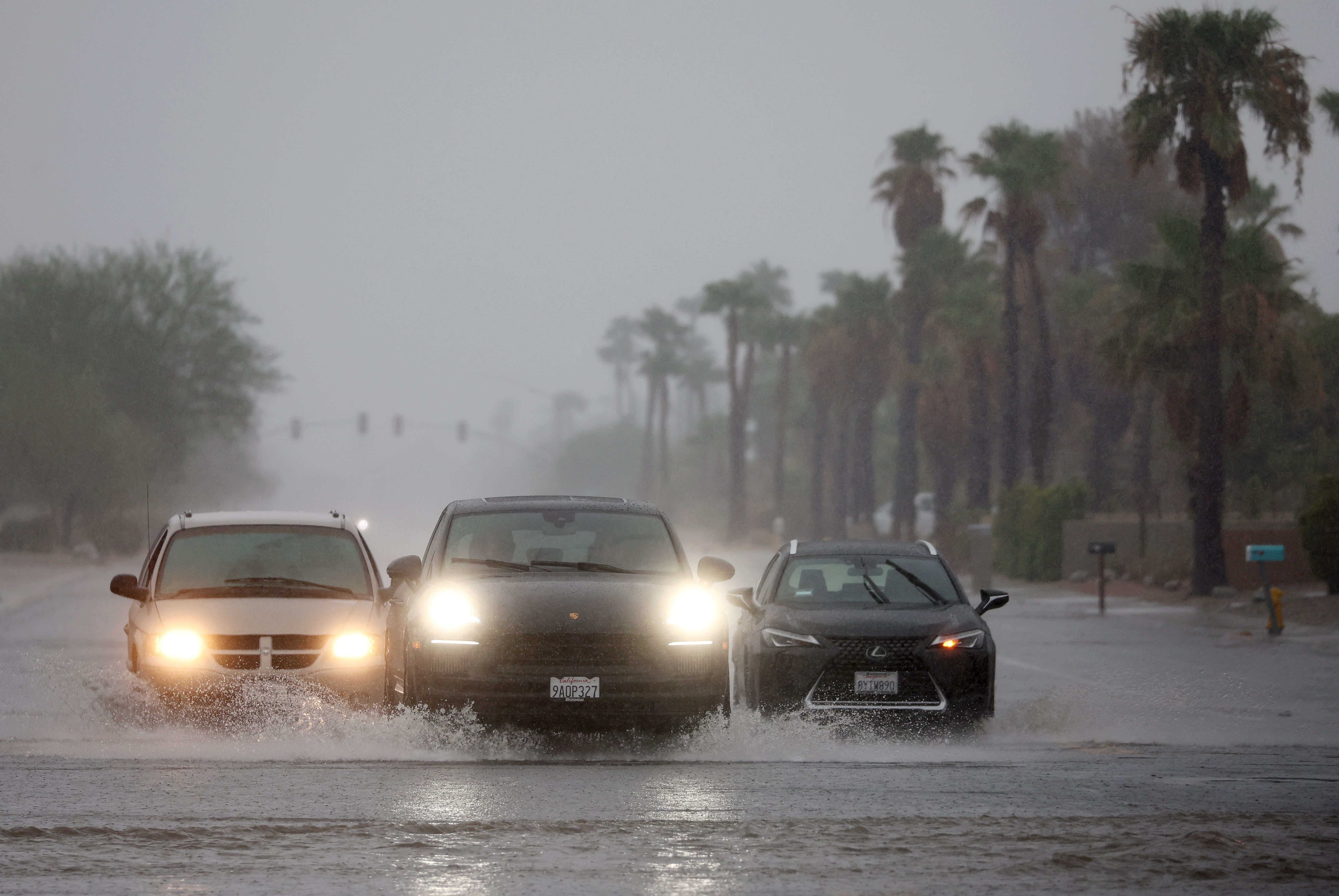 Vehicles drive along a flooded street as Tropical Storm Hilary approaches on August 20, 2023 in Palm Springs, California. Southern California is under a first-ever tropical storm warning as Hilary nears, with parts of California, Arizona and Nevada preparing for flooding and heavy rains. All California state beaches have been closed in San Diego and Orange counties in preparation for the impacts from the storm, which was downgraded from hurricane status. 