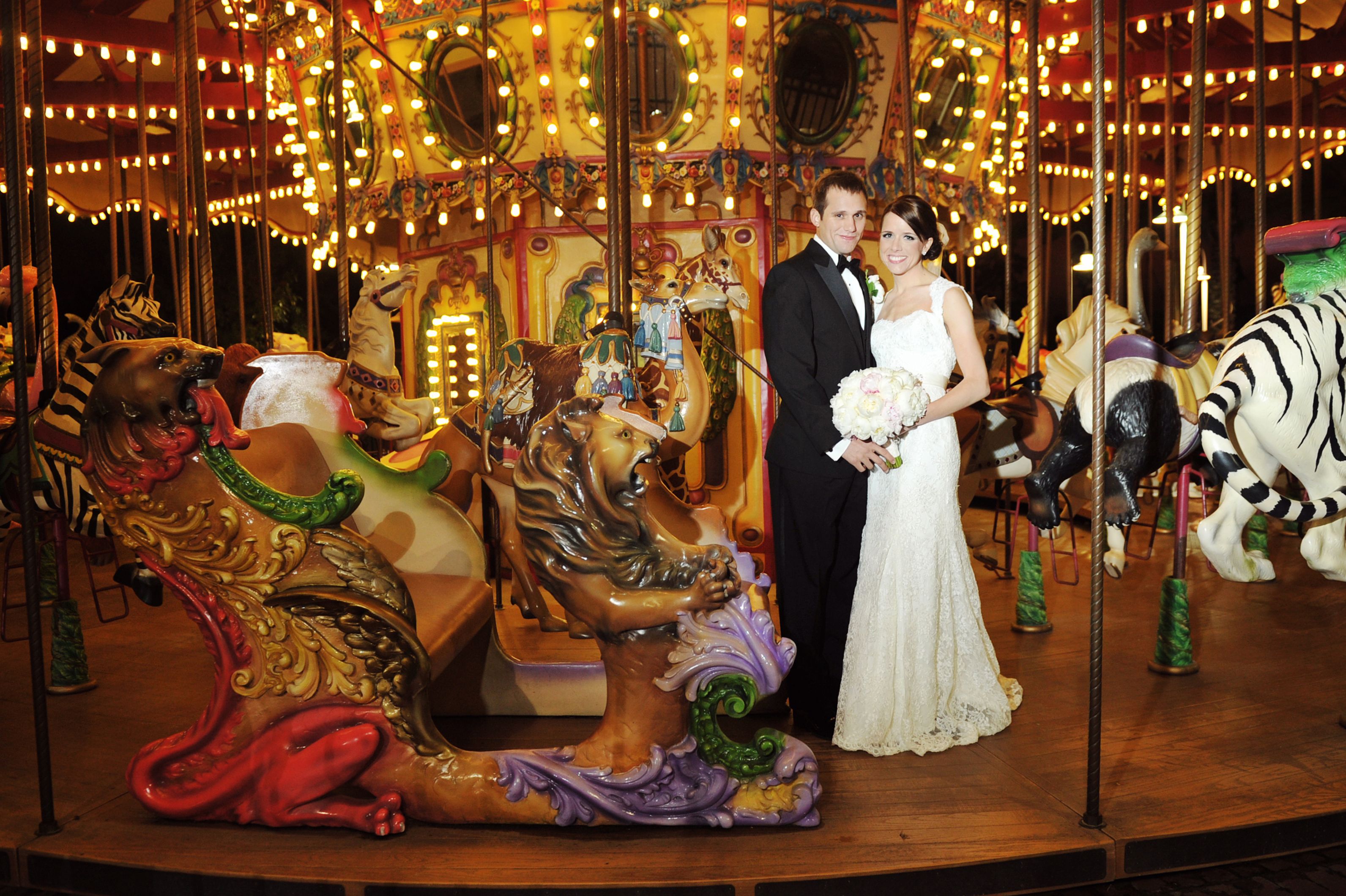 Photo shows a carousel lit up at night.